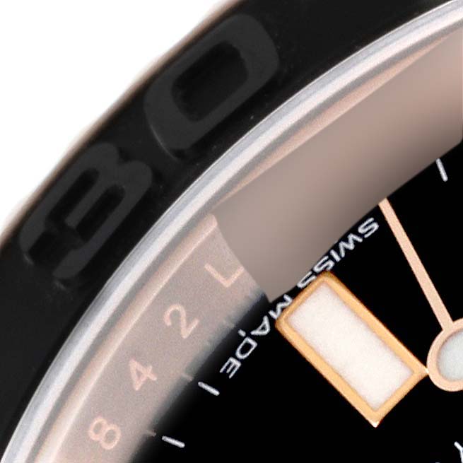 This close-up image of a Rolex Yacht-Master 116655 Men's Rose Gold Black Dial 116655 Men's Rose Gold Black Dial watch shows part of the bezel, the minute markers, and a portion of the watch face with an hour marker.