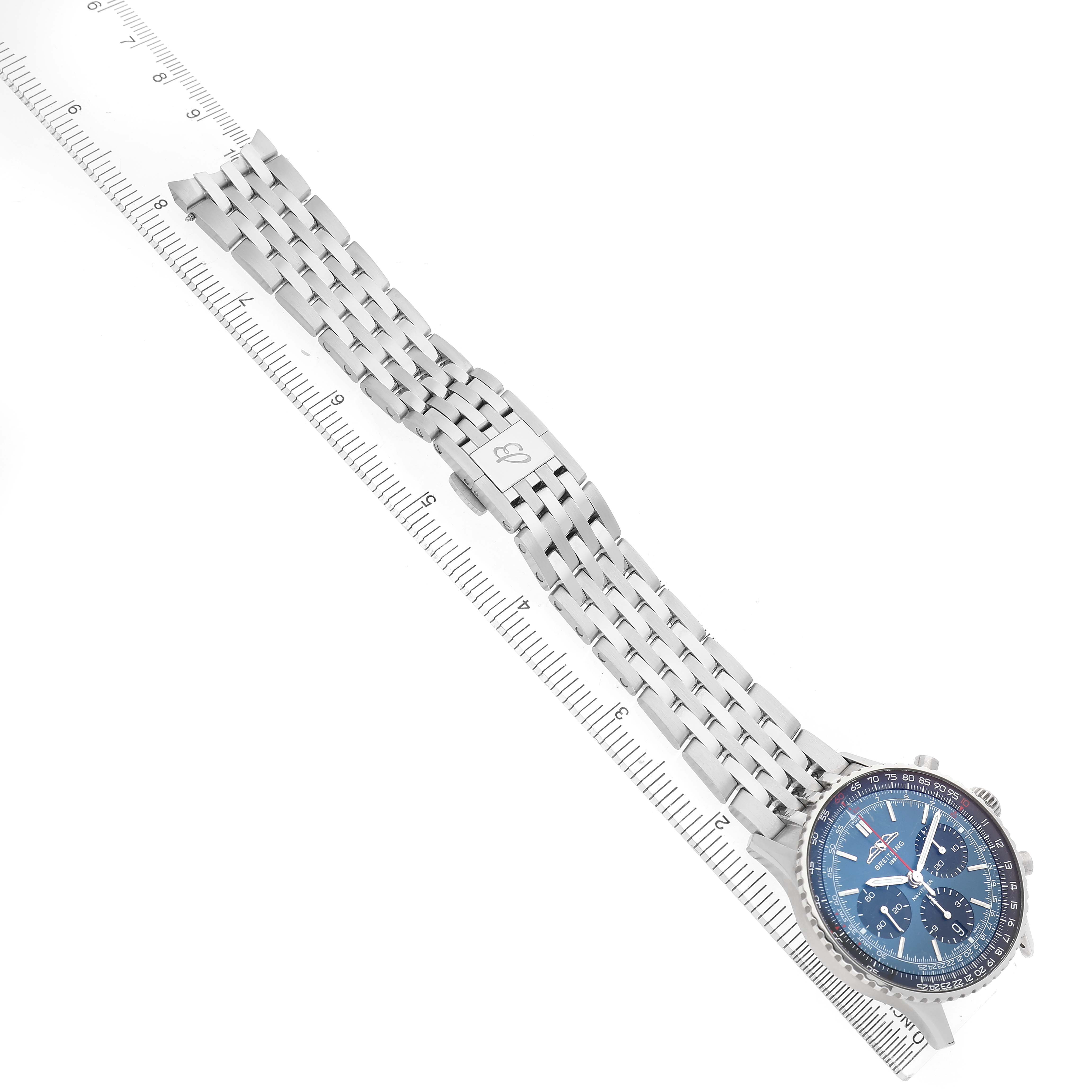 The Breitling Navitimer AB0139241C1A1 Men's Stainless Steel Blue Dial watch is shown at a top-down angle, displaying its face and stainless steel bracelet alongside a ruler.