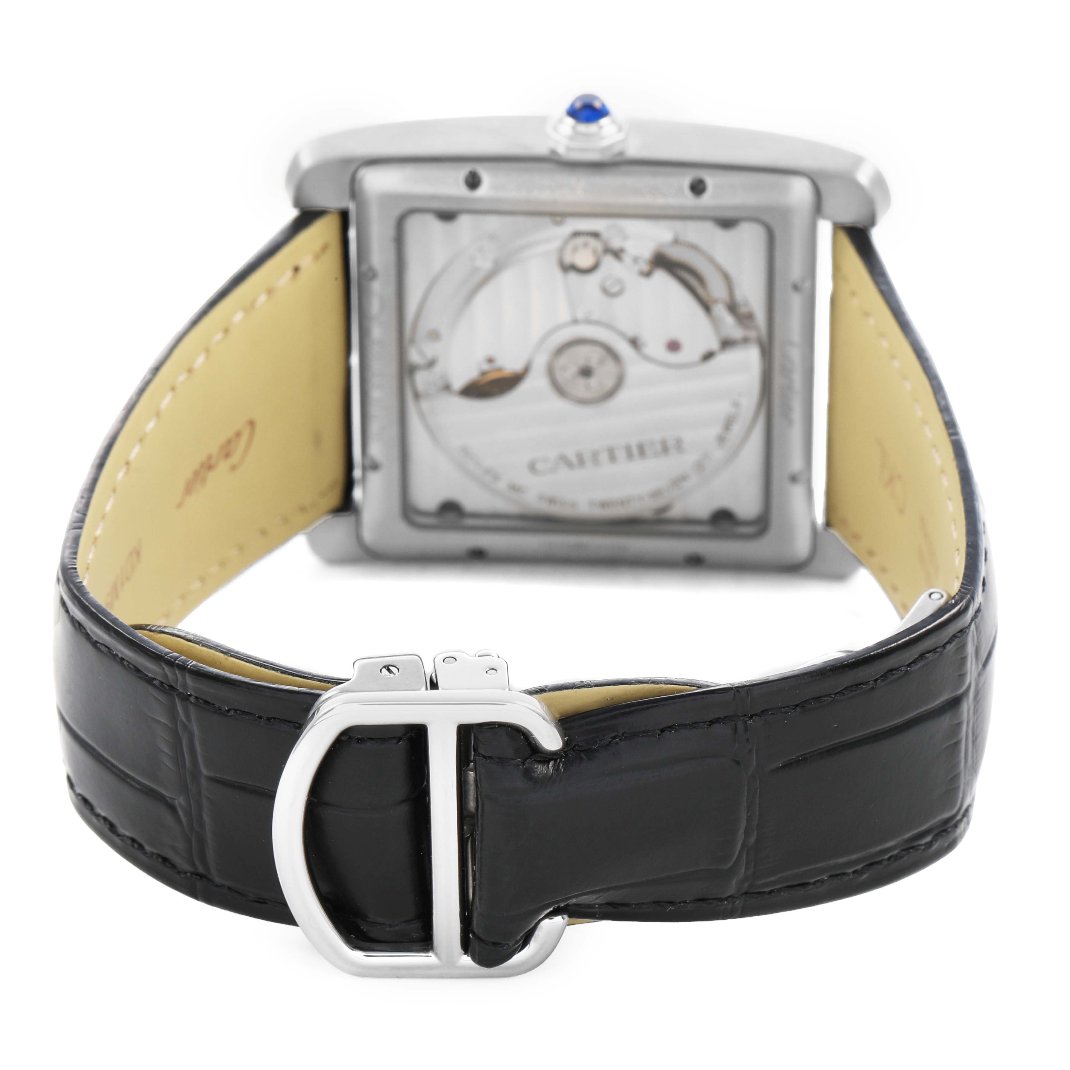 The Cartier Tank MC W5330003 Men's Stainless Steel Silver Dial watch is shown from the back, displaying its movement through a transparent case and leather strap with a buckle.