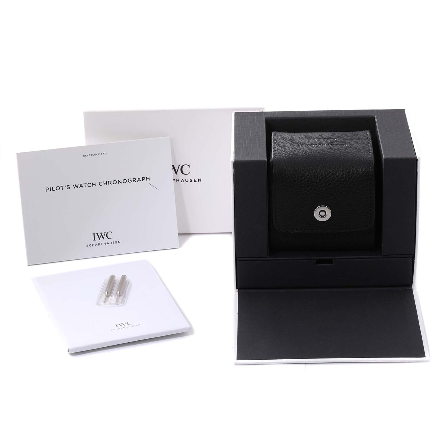 The image shows a Pilot model by IWC's packaging, including the watch case, instruction manual, and warranty card from a front angle.