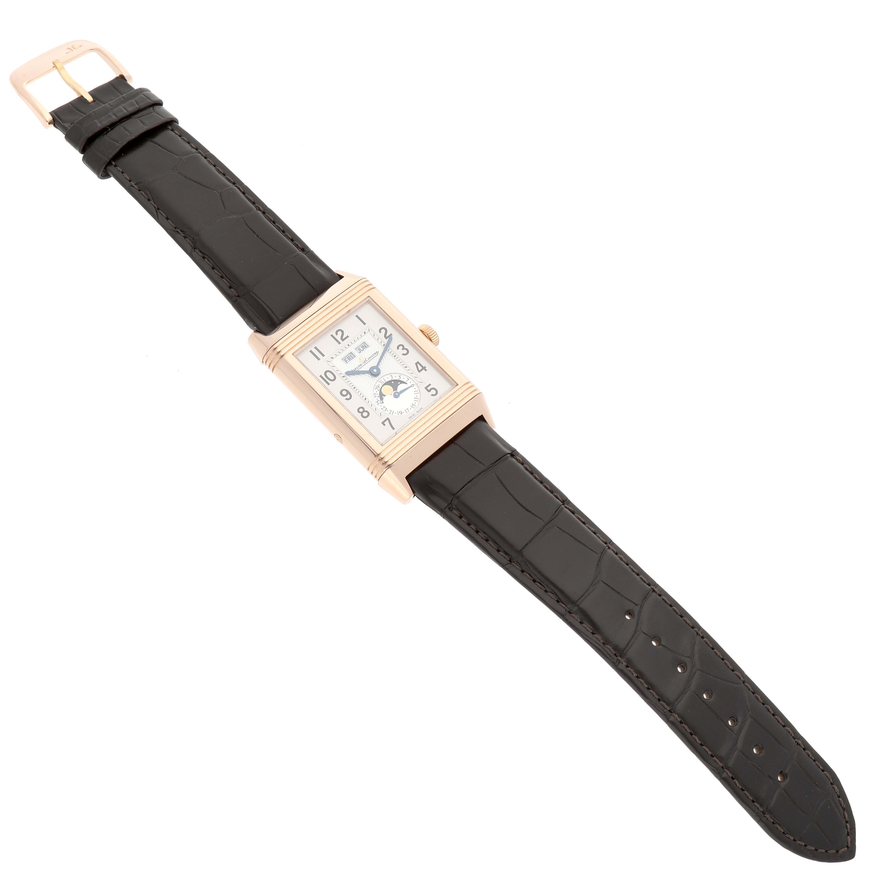 The Jaeger-LeCoultre Reverso watch is shown from a top-down angle, displaying its rectangular face, case, strap, and buckle.