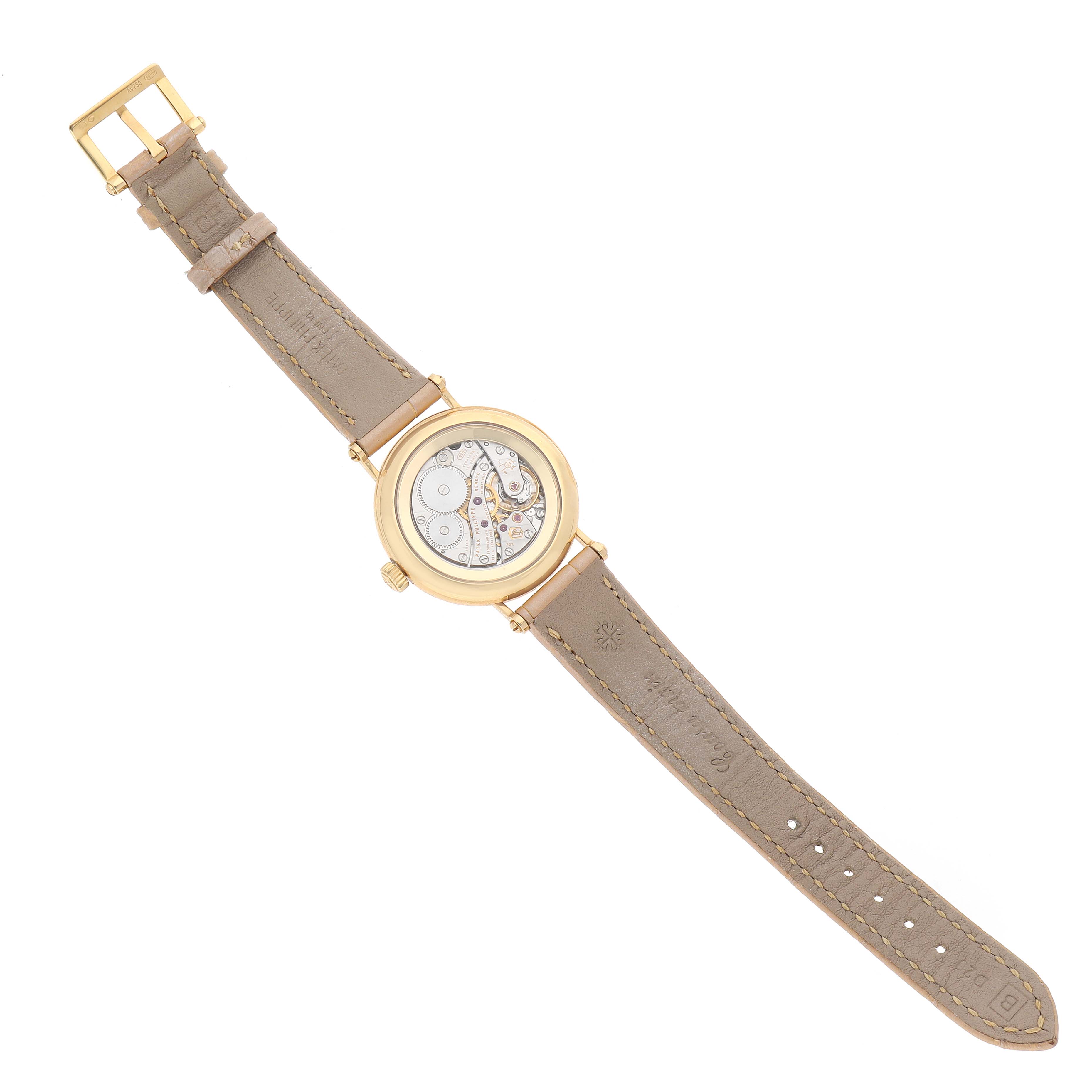 The image shows a Patek Philippe Calatrava 7121J-001 Women's Yellow Gold Silver Dial watch from the back, displaying its movement and a leather strap.