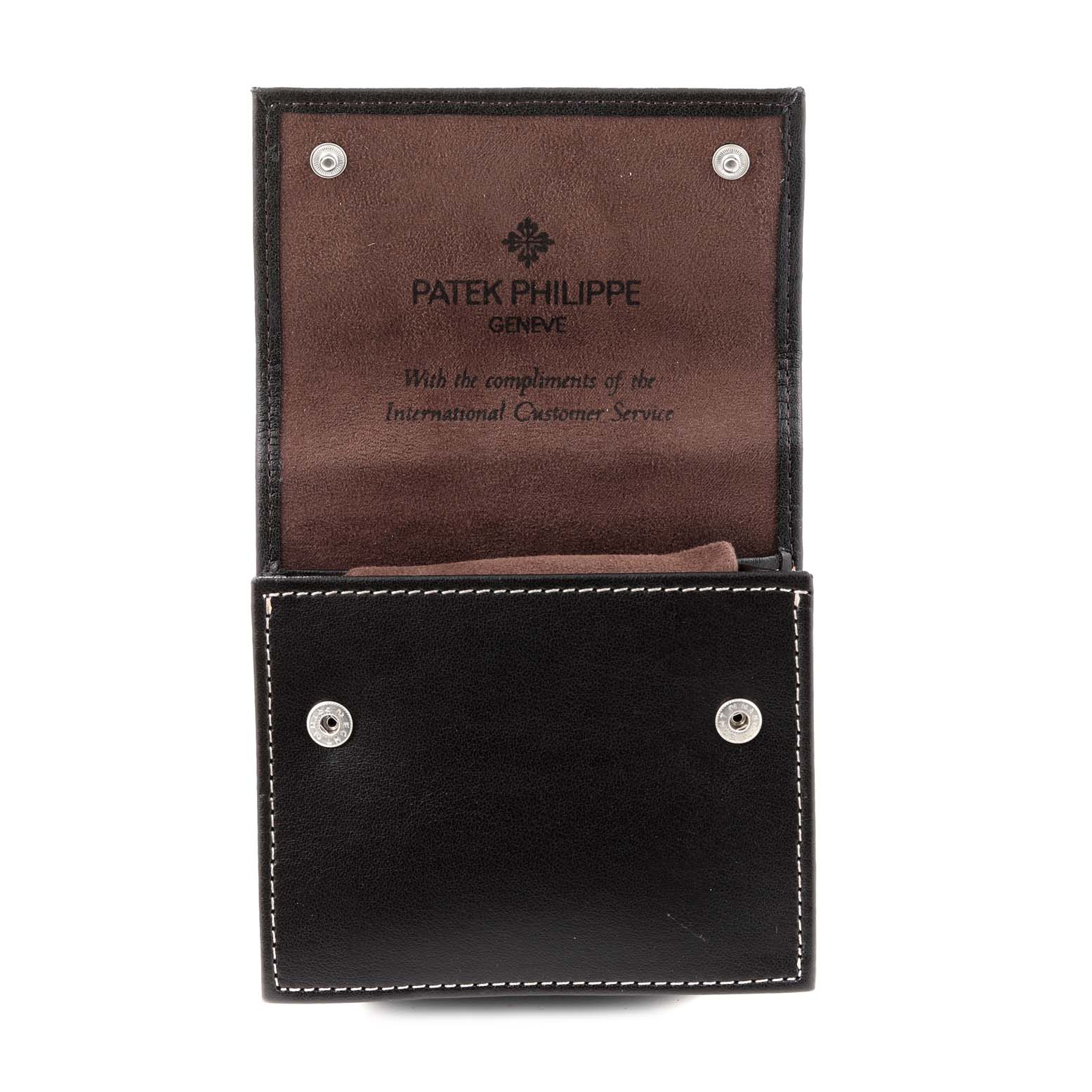 The image shows an open Patek Philippe Twenty-4 4910/20 Women's White Gold Grey Dial 4910/20 Women's White Gold Grey Dial watch case, displaying the interior with a suede lining and press-stud fasteners.