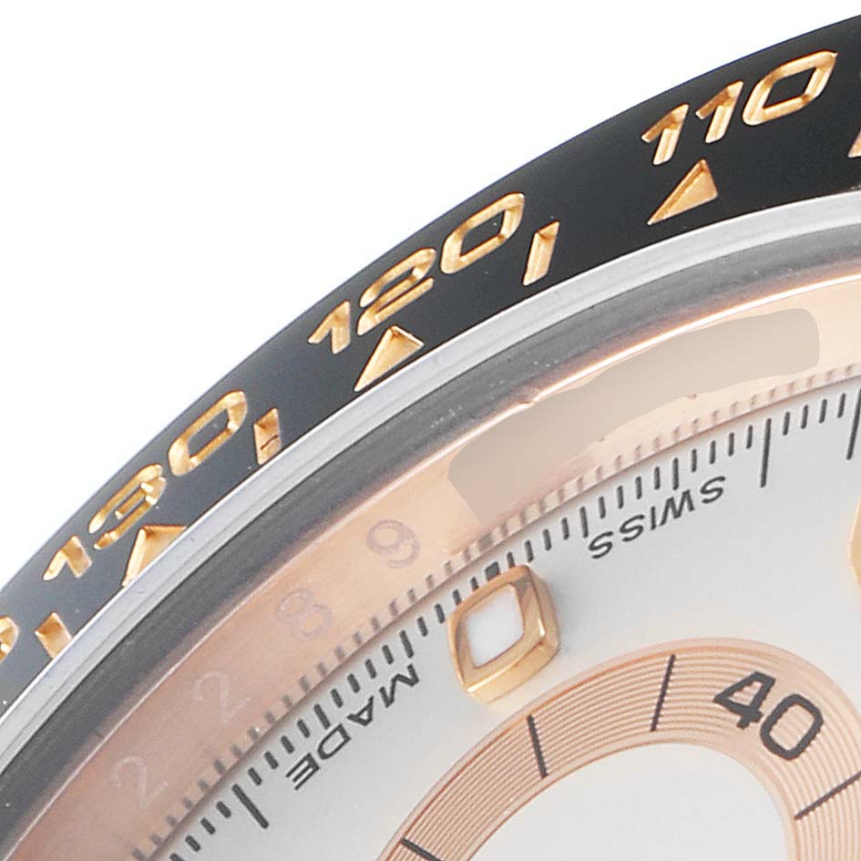 This close-up shot of a Rolex Daytona 116515LN Men's Rose Gold Silver Dial 116515LN Men's Rose Gold Silver Dial watch shows part of the bezel with tachymeter scale and a portion of the dial.