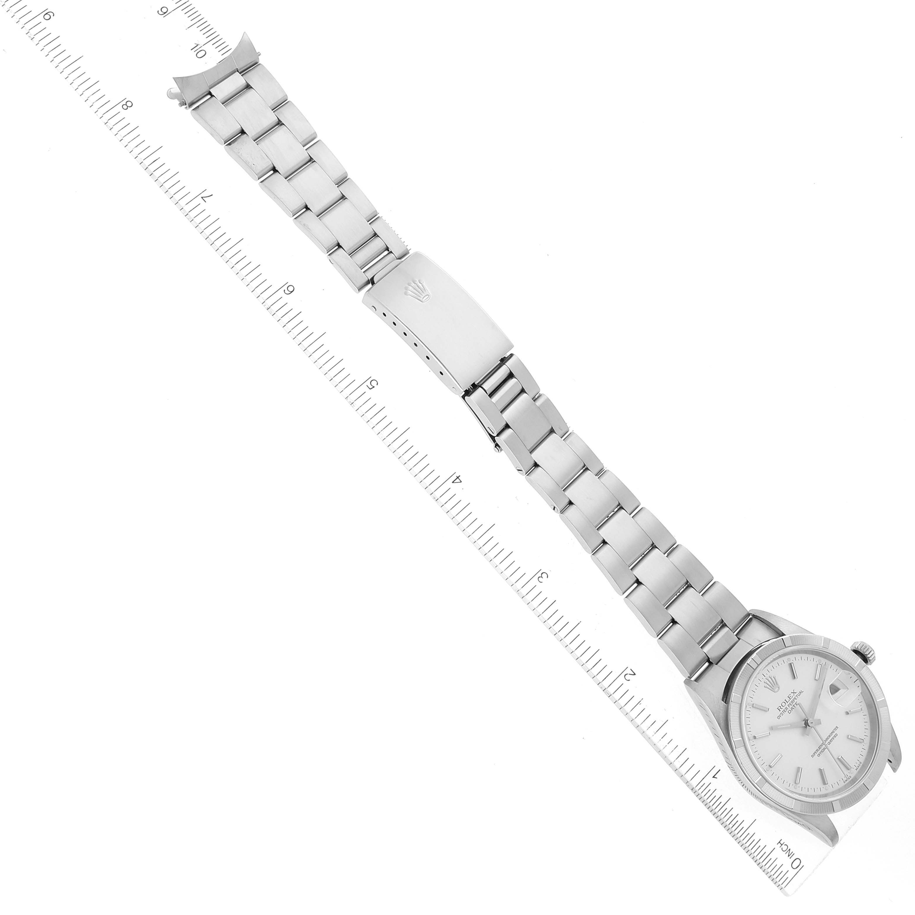 This image shows a top-down view of a Rolex Date 15210 Men's Stainless Steel Silver Dial 15210 Men's Stainless Steel Silver Dial model watch, including its dial and bracelet alongside a ruler for scale.