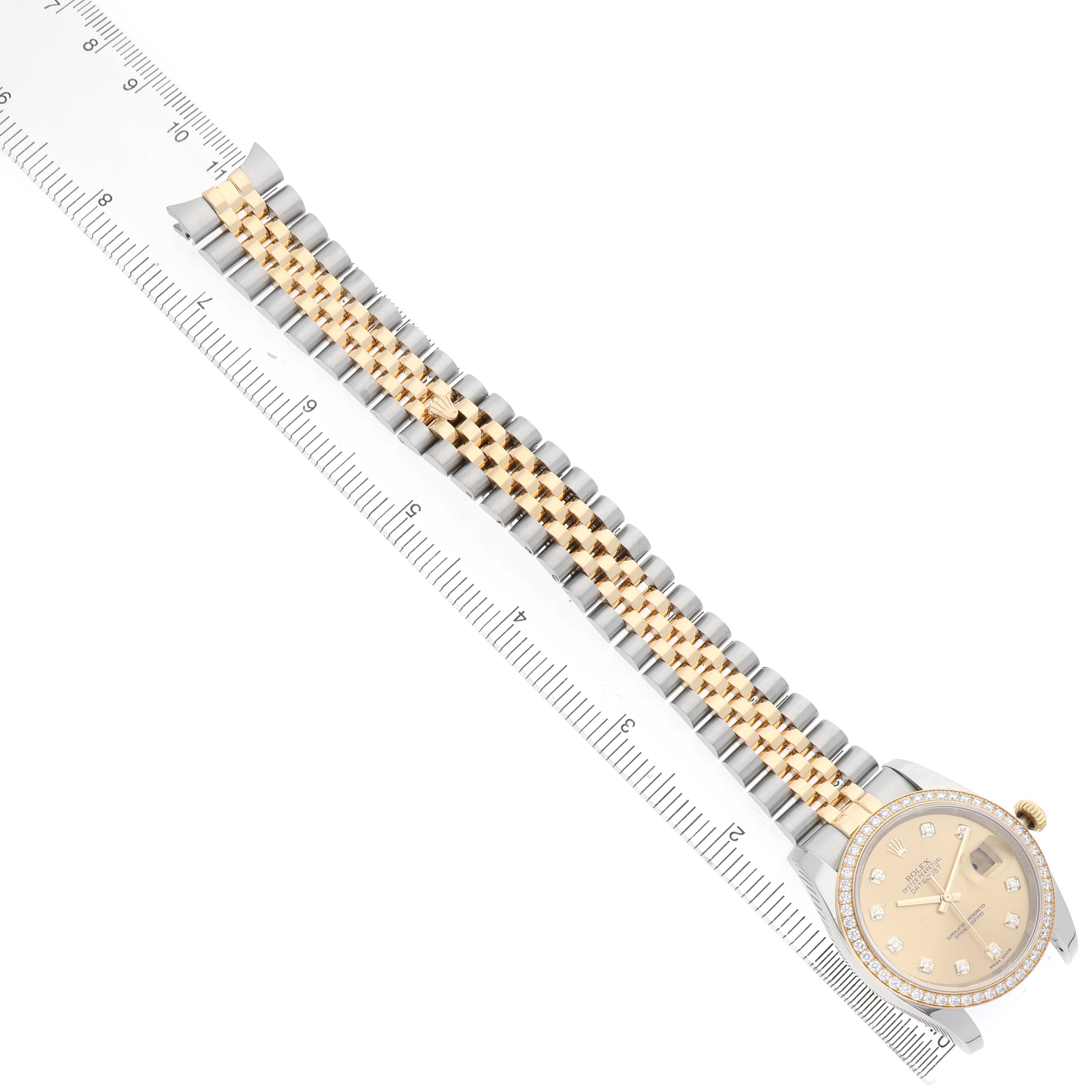 The Rolex Datejust 116243 Men's Steel and Gold (two tone) Champagne Dial watch is shown at an angle displaying its full band and face, alongside a ruler for scale.