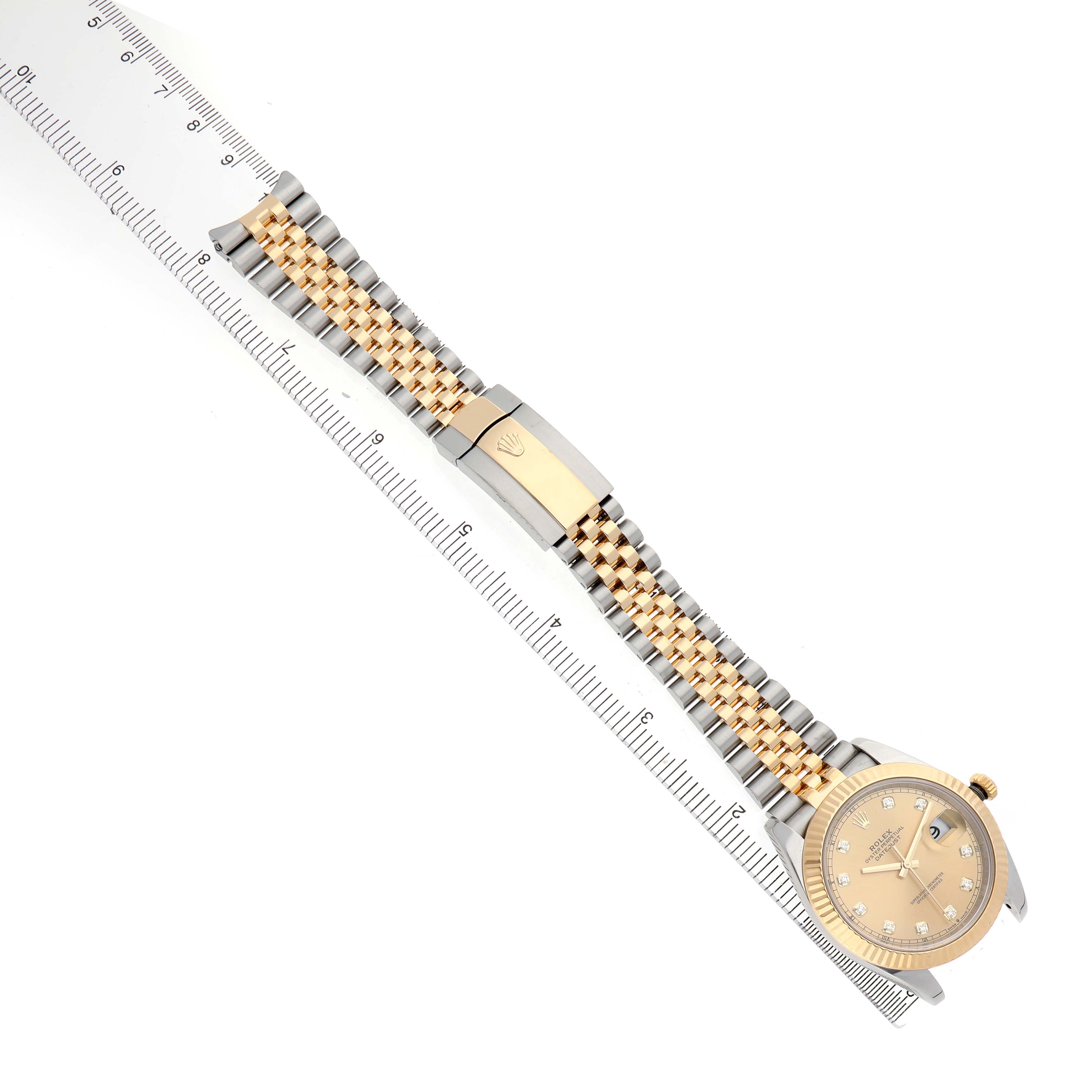The Rolex Datejust 41 126333 Men's Steel and Gold (two tone) Champagne Dial is shown from a top view, highlighting the dial, bracelet, and clasp alongside a ruler for scale.