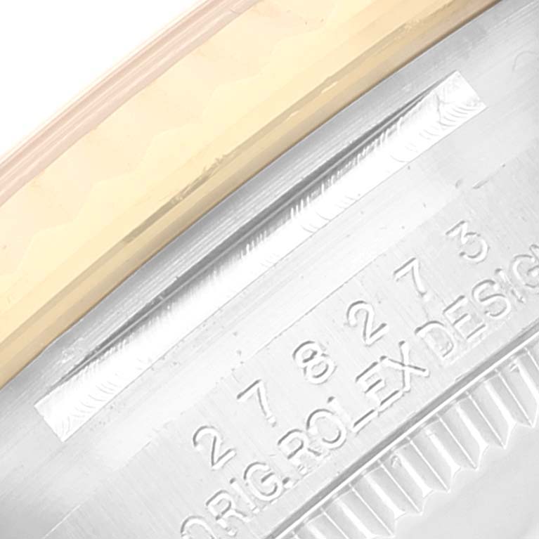 This close-up image shows the serial number and part of the bezel of a Mid-Size Rolex watch.