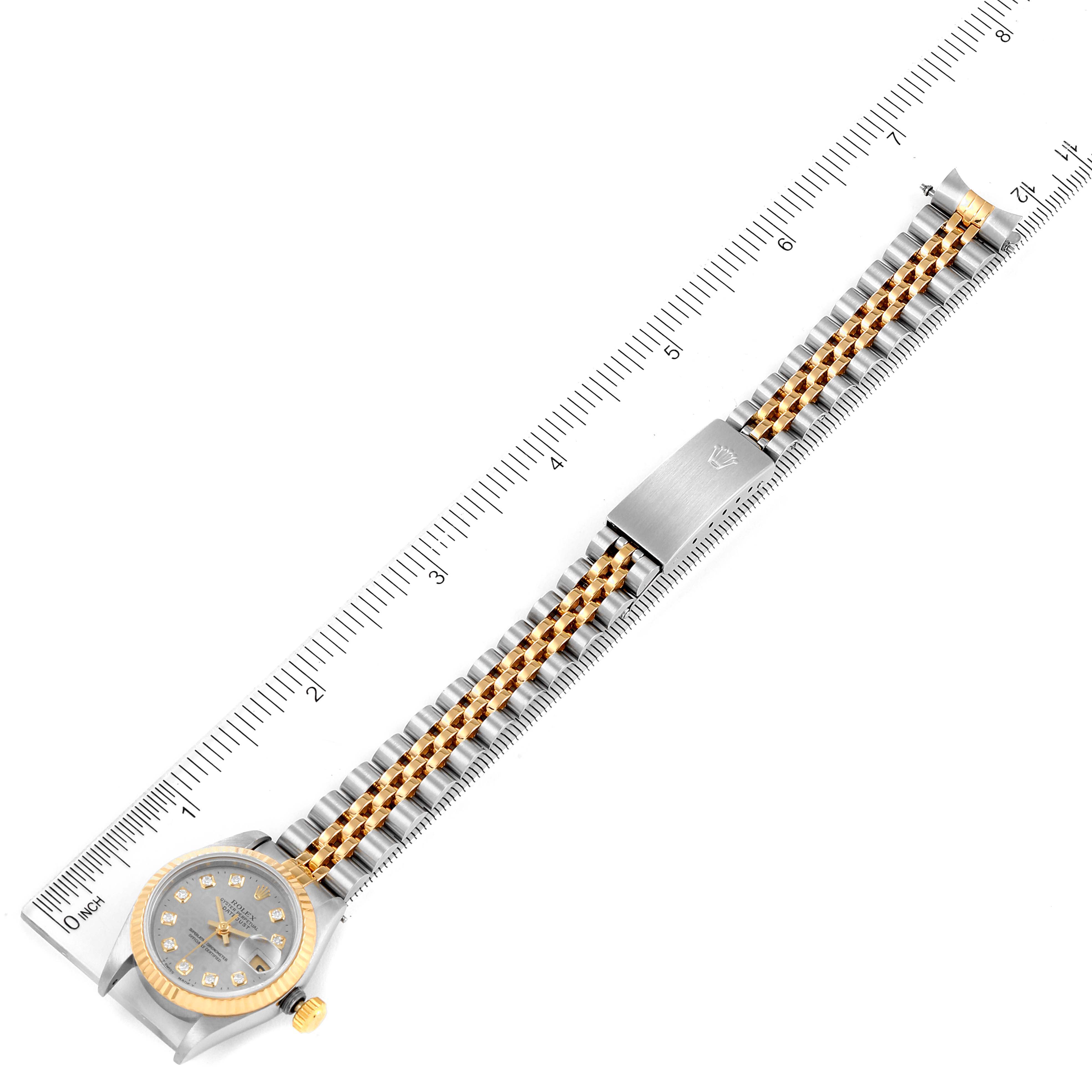 The image shows a top-down view of a Rolex Datejust 69173 Women
s Steel and Gold (two tone) Grey Dial 69173 Women
s Steel and Gold (two tone) Grey Dial watch, highlighting the dial, bezel, bracelet, and clasp against a ruler.