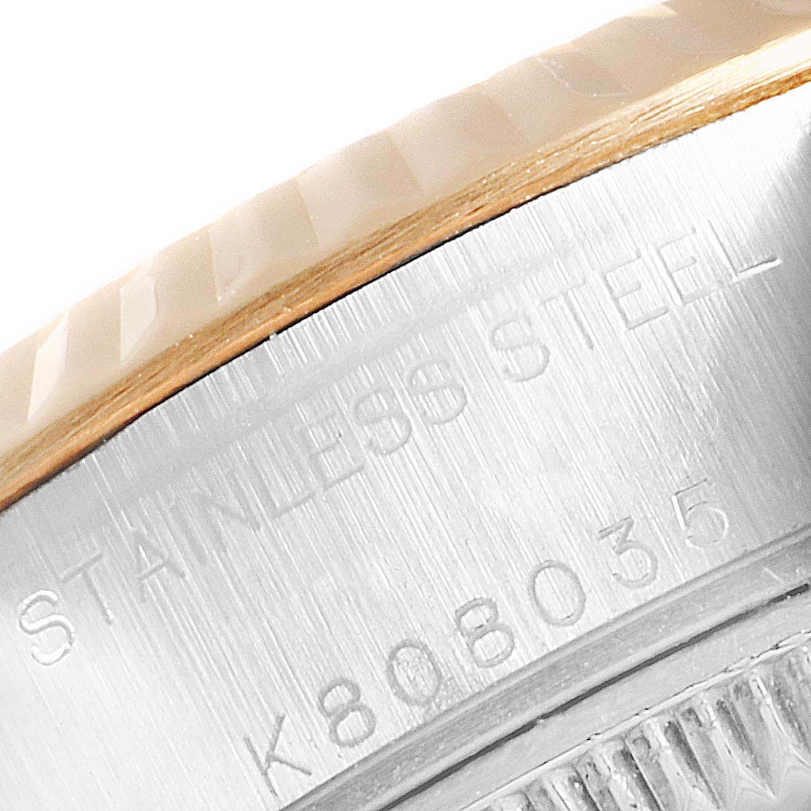 This close-up image shows the "STAINLESS STEEL" text and serial number on the bezel of a Rolex Datejust 79173 Women
s Steel and Gold (two tone) Mother of Pearl Dial 79173 Women
s Steel and Gold (two tone) Mother of Pearl Dial watch.