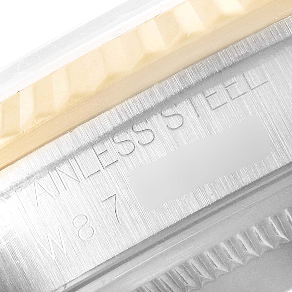 This close-up image shows the side of the bezel and part of the case with "STAINLESS STEEL" engraved on a Rolex Datejust 16233 Men's Steel and Gold (two tone) White Dial 16233 Men's Steel and Gold (two tone) White Dial watch.