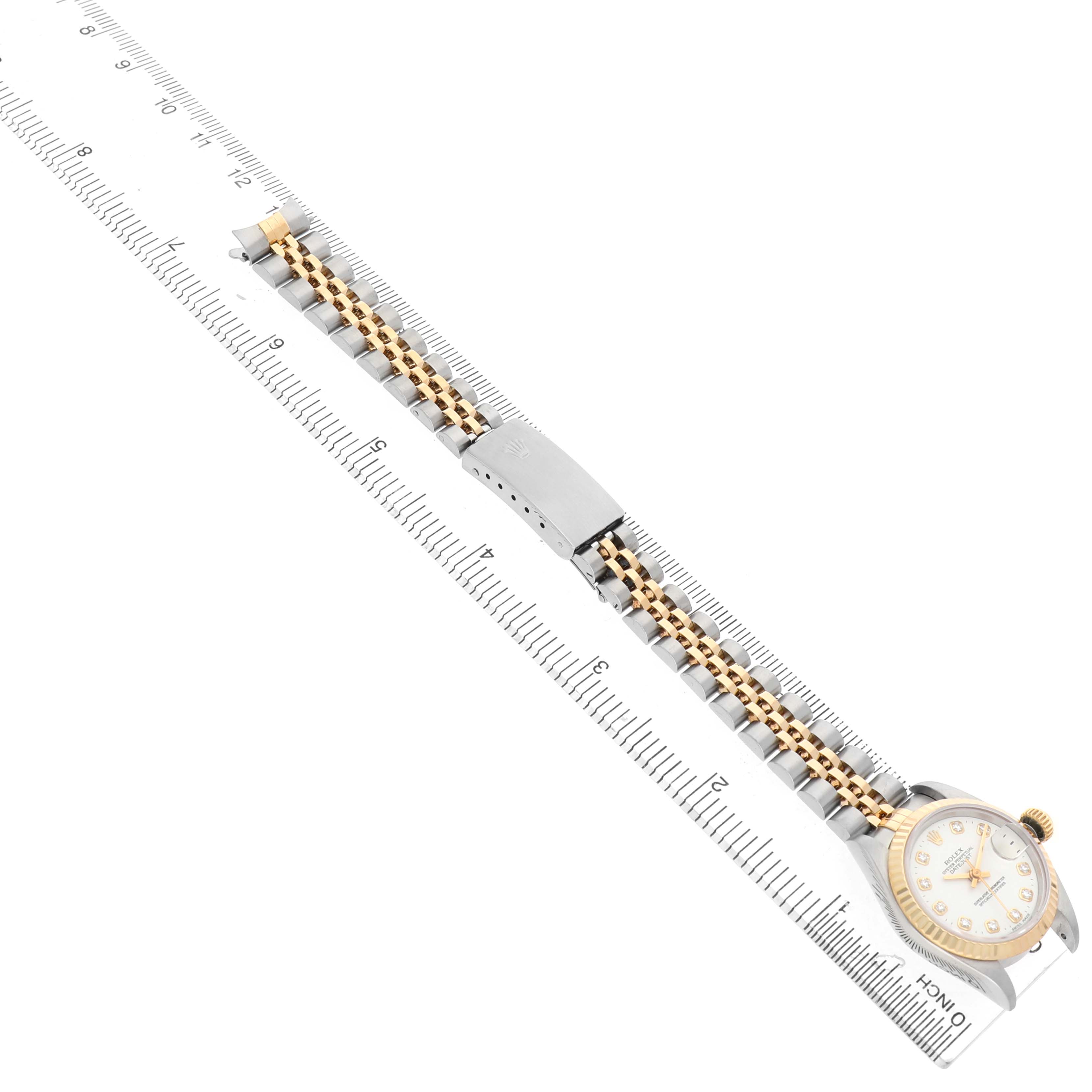 The Rolex Datejust 69173 Women's Steel and Gold (two tone) White Dial watch is shown diagonally with its bracelet and case, placed on a ruler for measurement.