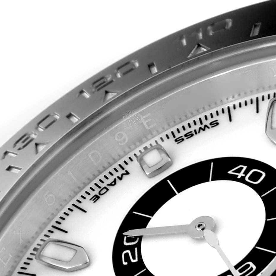 The image shows a close-up of the bezel and part of the dial of a Rolex Daytona 116500 Men's Stainless Steel White Dial 116500 Men's Stainless Steel White Dial watch.
