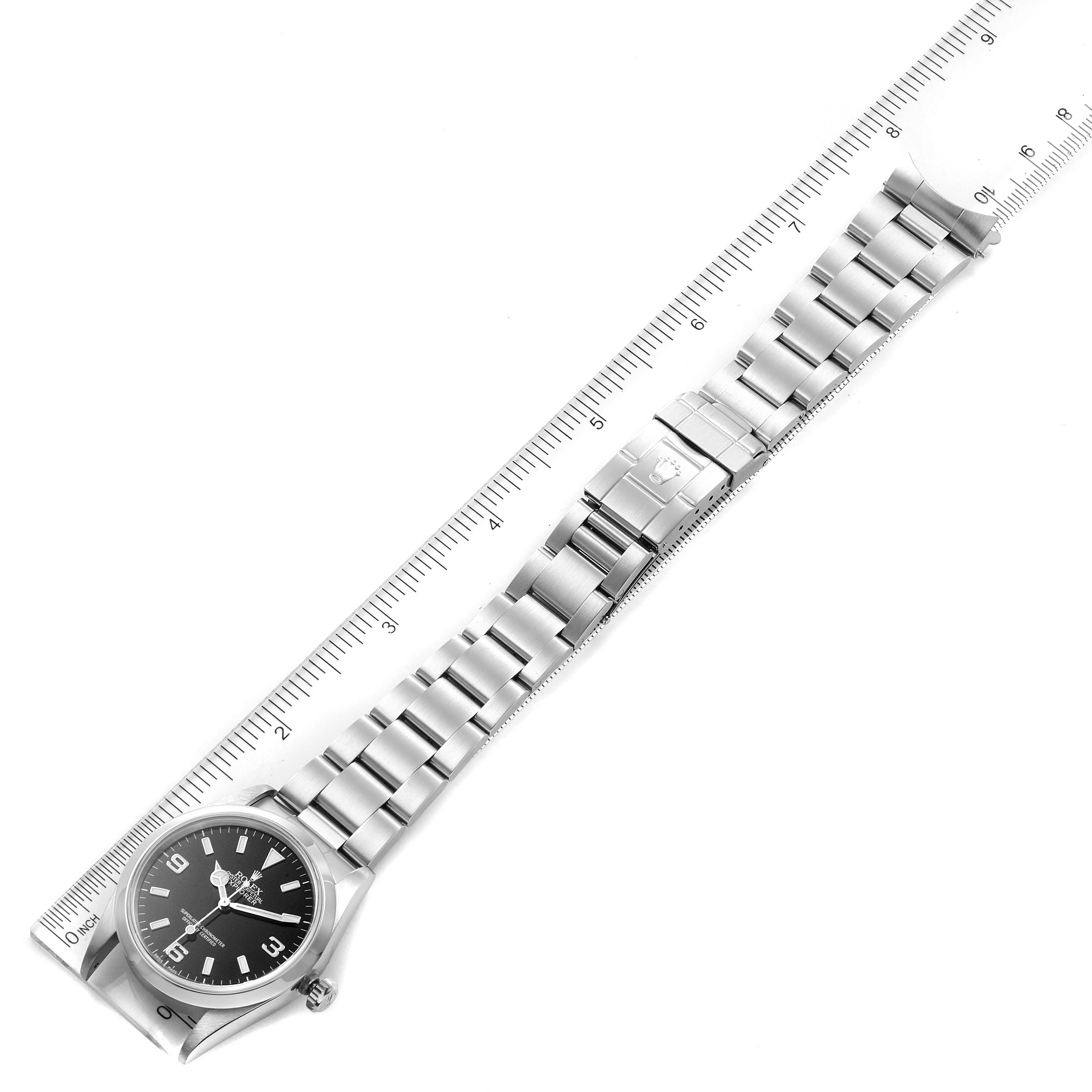 The image shows a Rolex Explorer 14270 Men's Stainless Steel Black Dial 14270 Men's Stainless Steel Black Dial watch laid flat alongside a ruler, displaying its full stainless steel bracelet and clasp.