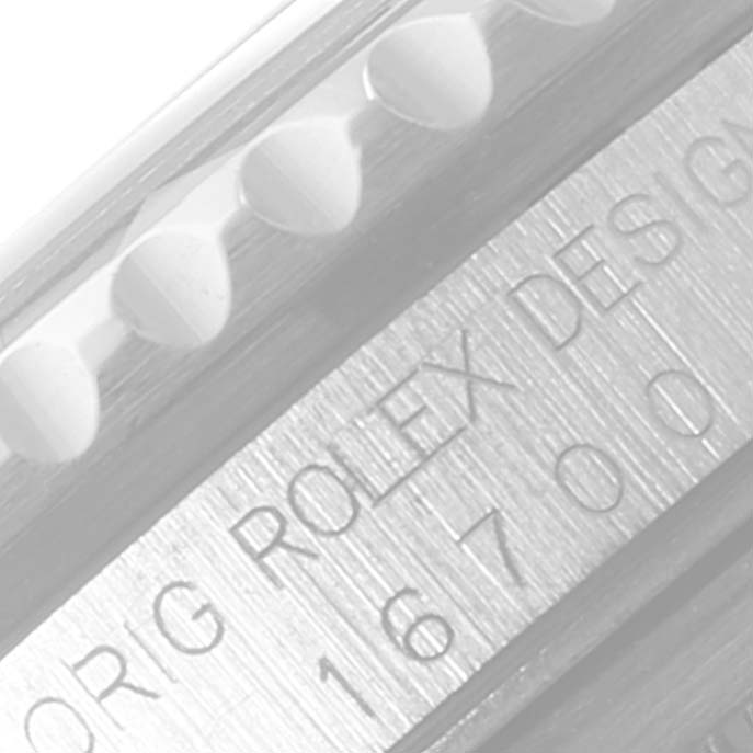 The image shows a close-up of the engraved side of a Rolex GMT-Master 16700 Men
s Stainless Steel Black Dial 16700 Men
s Stainless Steel Black Dial watch, featuring the model number and the bezel
s edge.