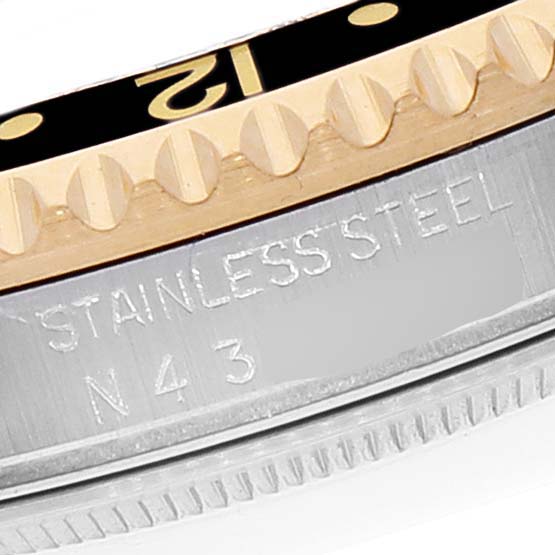 This is a close-up view of the bezel and case of a Rolex GMT-Master 16713 Men's Steel and Gold (two tone) Black Dial 16713 Men's Steel and Gold (two tone) Black Dial, showing the "12" marker and "STAINLESS STEEL N43" inscription.
