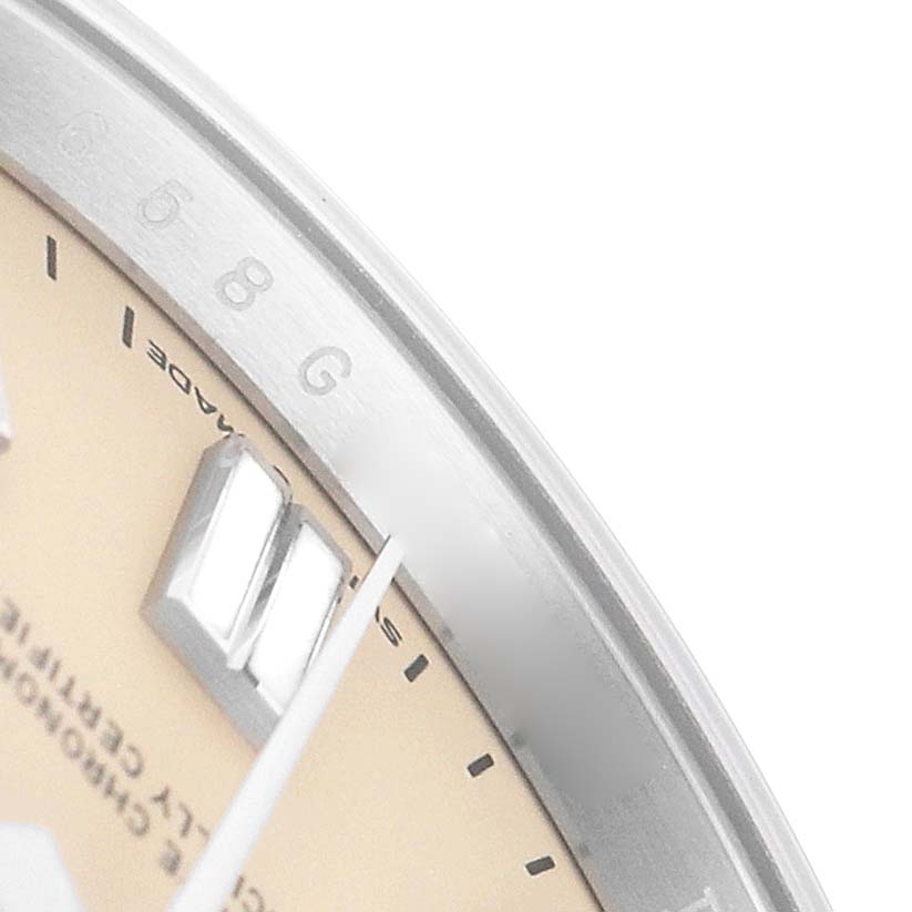 The image shows a close-up of the Rolex Oyster Perpetual 134300 Men's Stainless Steel Beige Dial's dial edge, showcasing hour markers, the second hand, and part of the bezel.