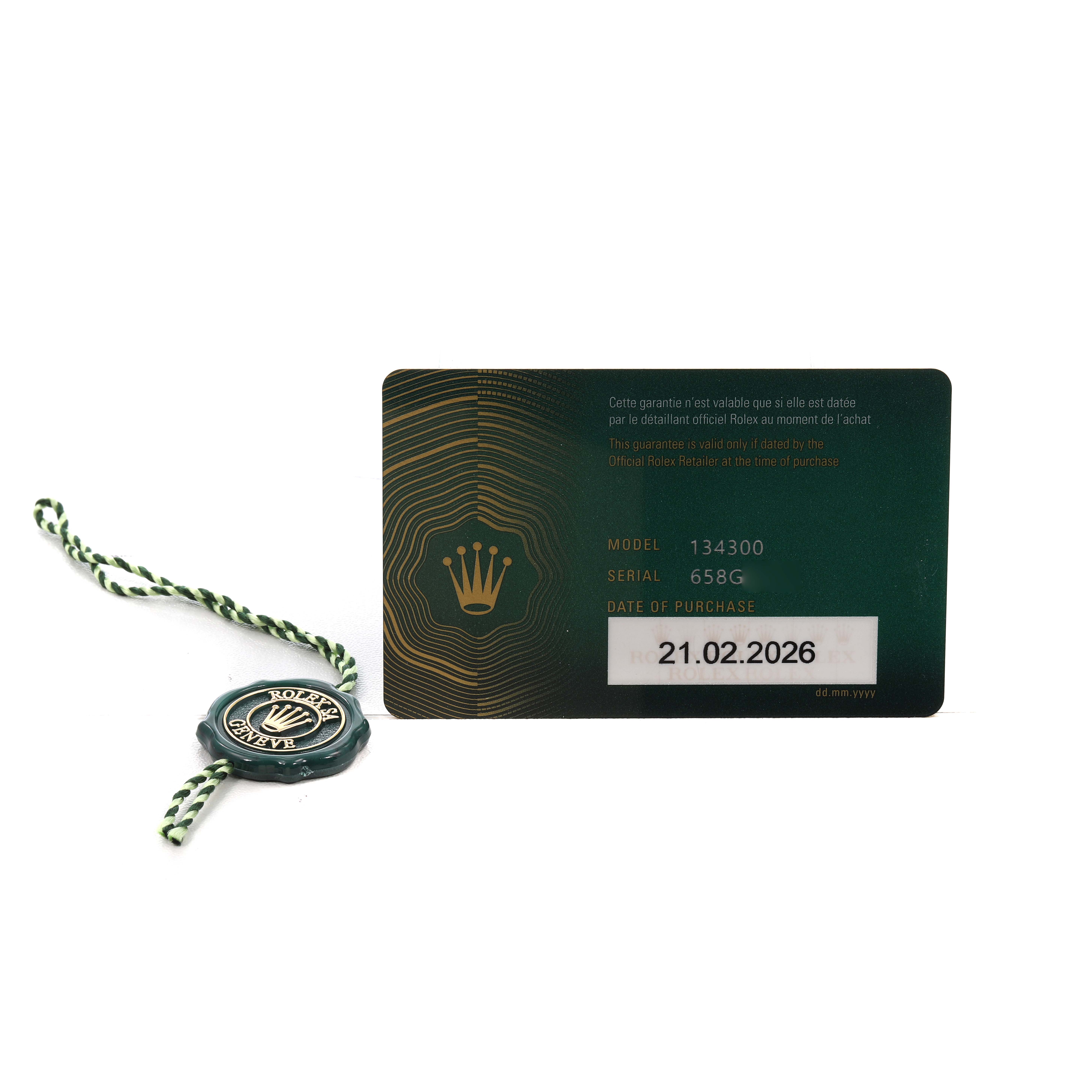 The image shows the Rolex Oyster Perpetual 134300 Men's Stainless Steel Beige Dial's warranty card and a green seal tag.
