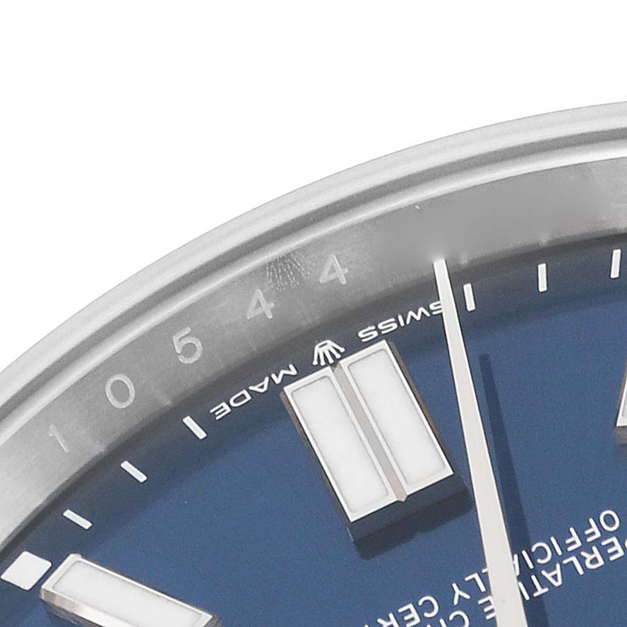 This image shows a close-up of the top-left section of the dial of a Rolex Oyster Perpetual 124300 Men
s Stainless Steel Blue Dial 124300 Men
s Stainless Steel Blue Dial watch, highlighting its markers and "Swiss Made" text.