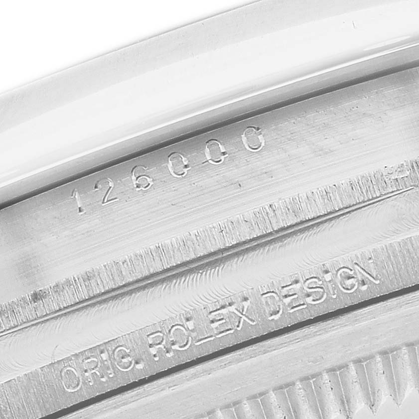 The image shows a close-up of the case side, featuring engraved details of the Rolex Oyster Perpetual 126000 Men's Stainless Steel Blue Dial model.