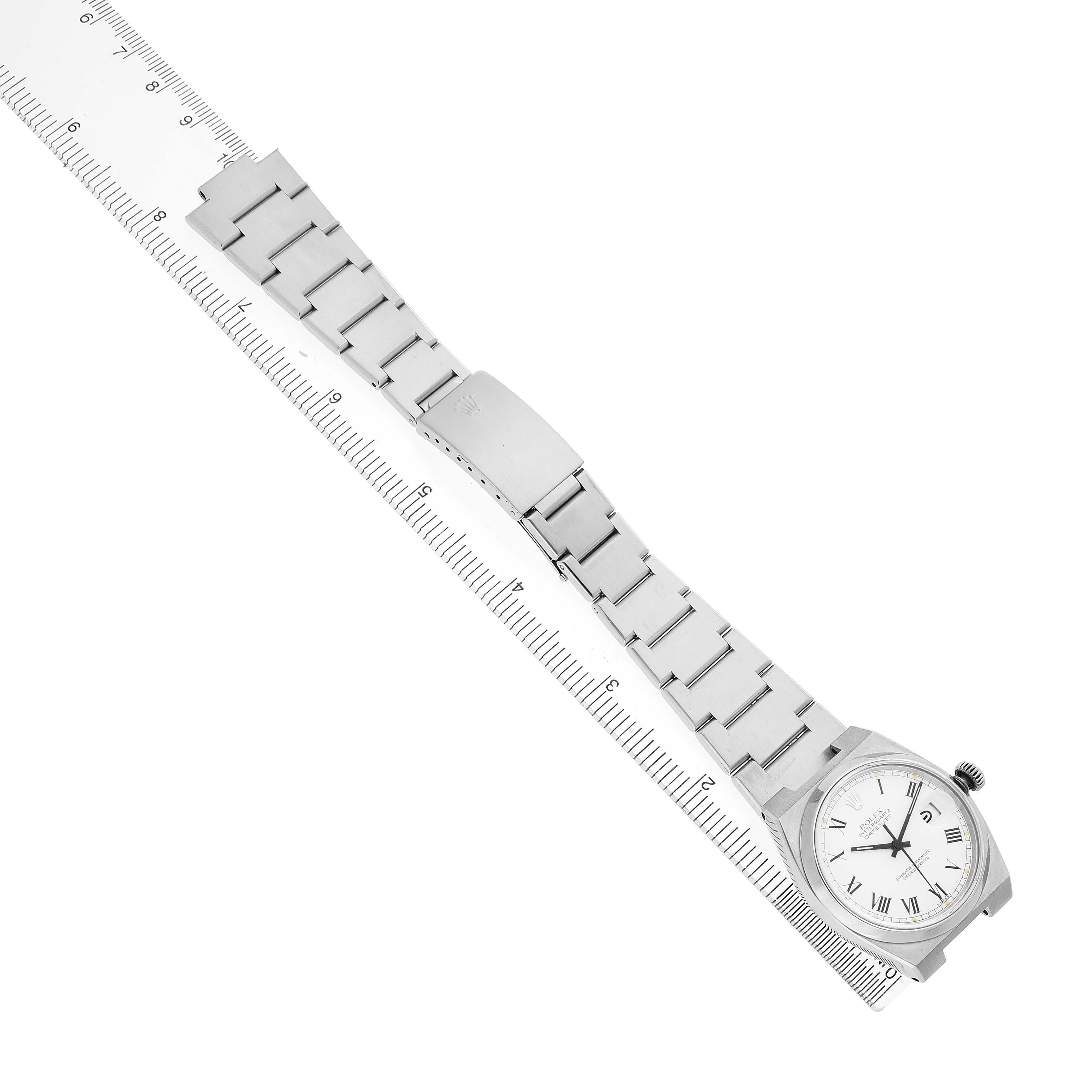 The Rolex Oysterquartz 17000 Men's Stainless Steel White Dial watch is displayed diagonally, showing the face and full metal bracelet, aligned with a ruler for scale.