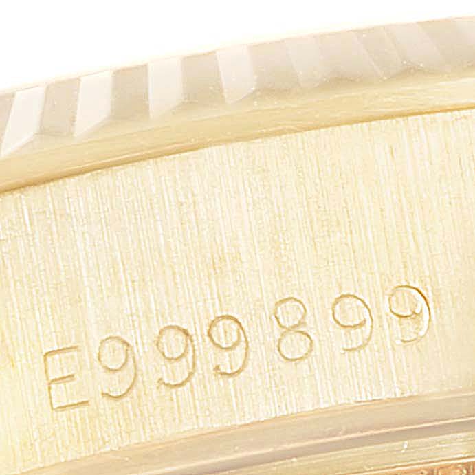 This close-up image of a Rolex President 69178 Women
s Yellow Gold Champagne Dial 69178 Women
s Yellow Gold Champagne Dial model watch shows the serial number and part of the bezel.