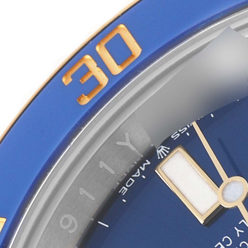 The image shows a close-up of the bezel, dial, and minute hand of a Rolex Submariner 126613 Men
s Steel and Gold (two tone) Blue Dial 126613 Men
s Steel and Gold (two tone) Blue Dial watch.