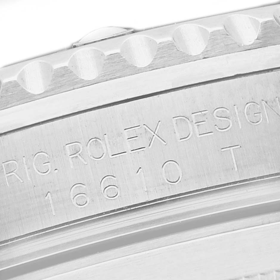The image shows a close-up of the engraved side of the case of a Rolex Submariner 16610 Men's Stainless Steel Black Dial 16610 Men's Stainless Steel Black Dial model, highlighting the model number 16610 T.