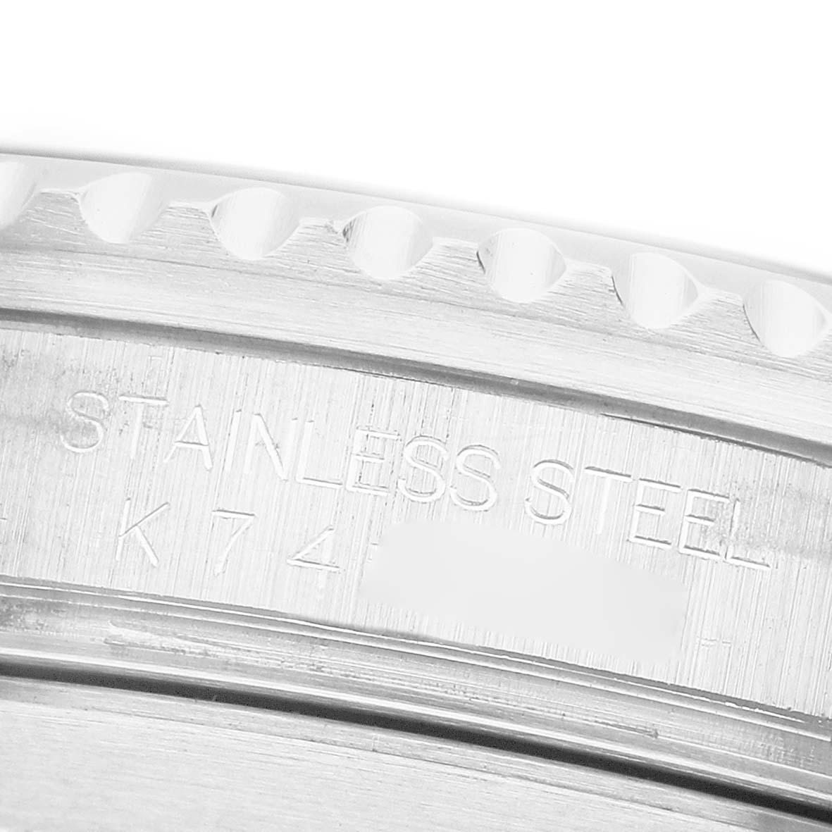 The image shows a close-up of the side of a Rolex Submariner 16610 Men's Stainless Steel Black Dial, highlighting the stainless steel engraving on the case.