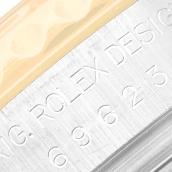 This close-up image shows the side view of the case of the Rolex Yacht-Master 69623 Women's Steel and Gold (two tone) White Dial 69623 Women's Steel and Gold (two tone) White Dial, featuring engraved serial numbers and part of the bezel.