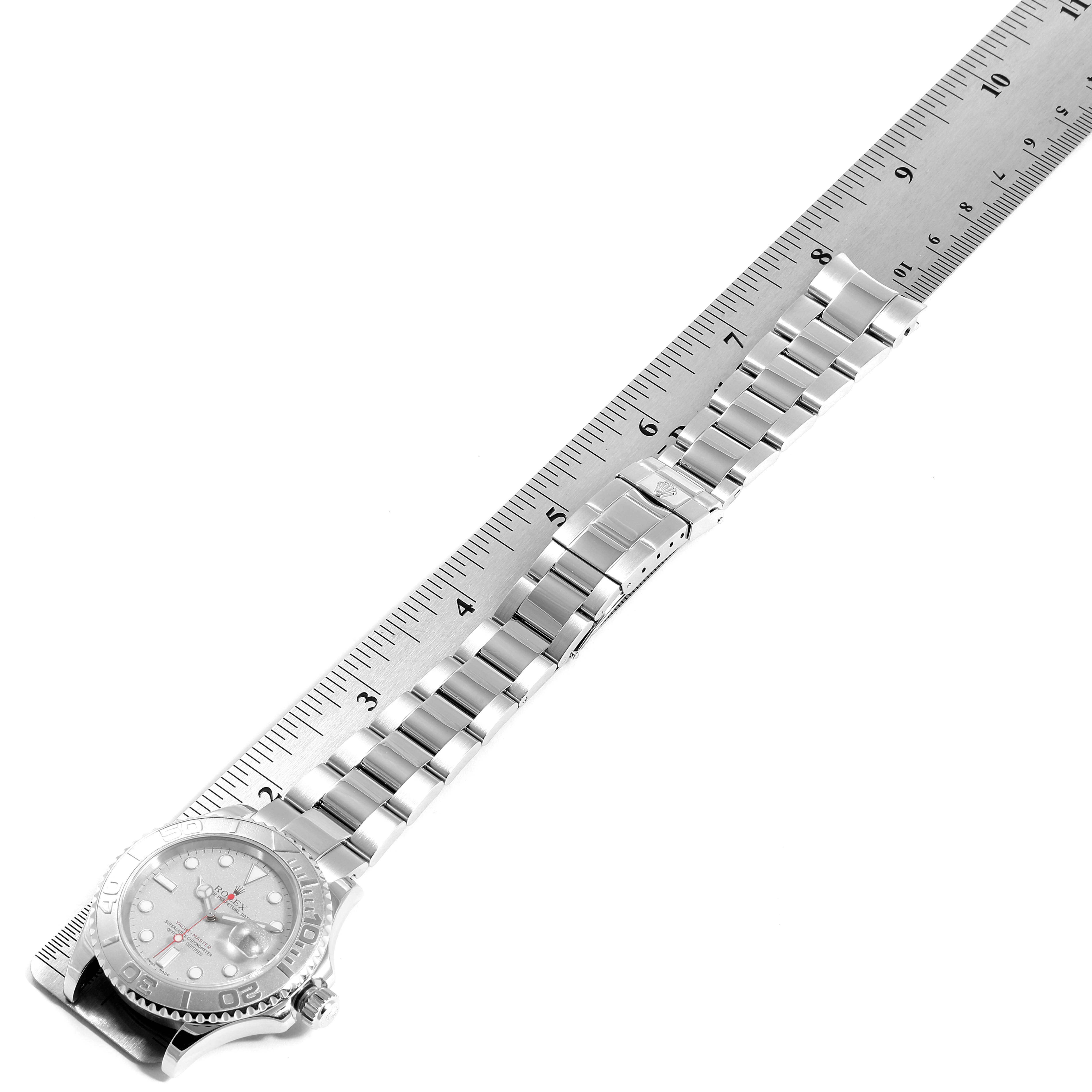 The image shows a side angle of a Rolex Yacht-Master 16622 Men
s Stainless Steel Silver Dial 16622 Men
s Stainless Steel Silver Dial watch and its metal bracelet beside a ruler for scale.