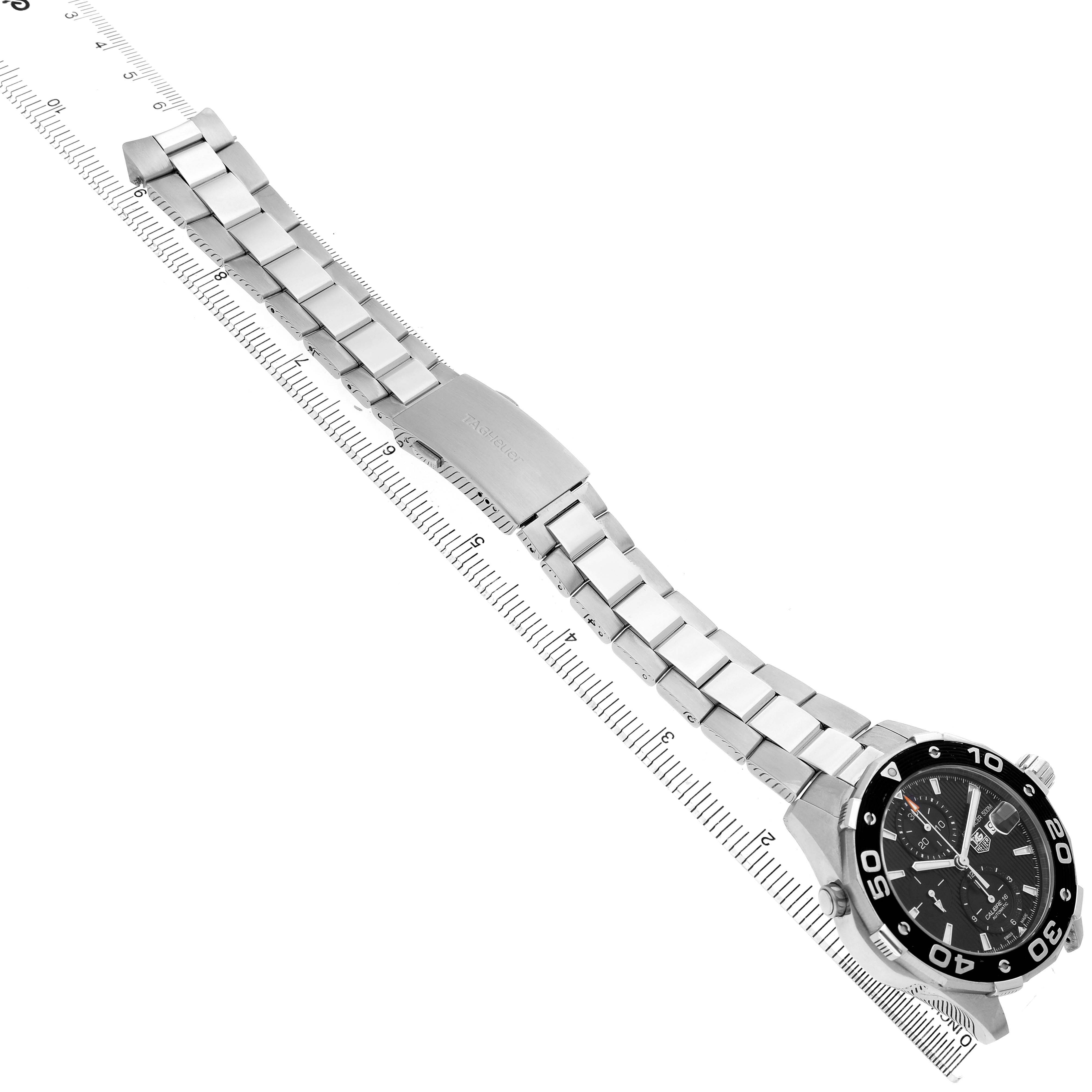 The Tag Heuer Aquaracer CAJ2110 Men's Stainless Steel Black Dial watch is shown from an overhead angle, displaying its bracelet, clasp, and face with a visible ruler for scale.