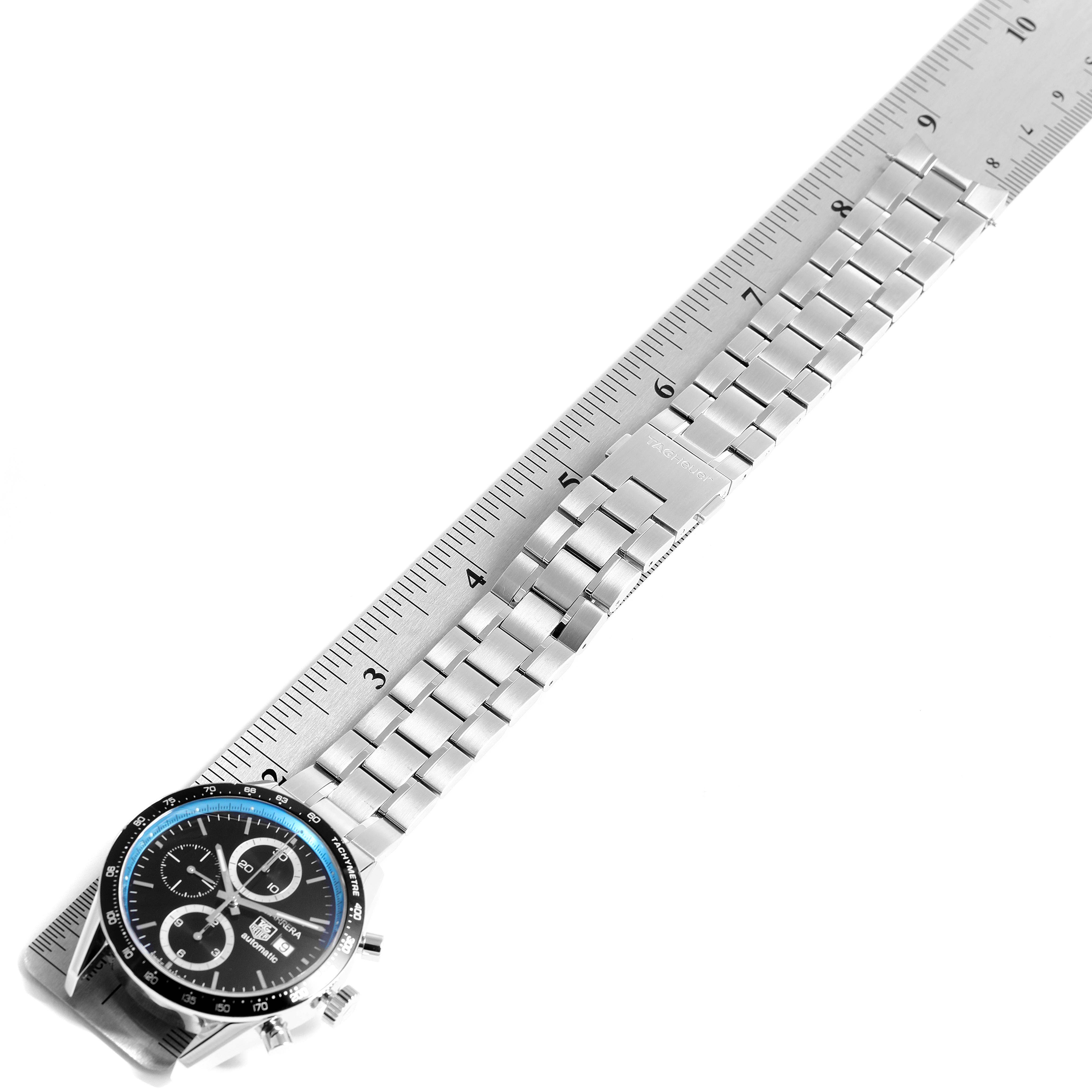 The image shows a top-down view of a Tag Heuer Limited Edition CV201X.BA0794 Men
s Stainless Steel Black Dial CV201X.BA0794 Men
s Stainless Steel Black Dial model watch, featuring its face, bezel, and metal bracelet alongside a ruler.