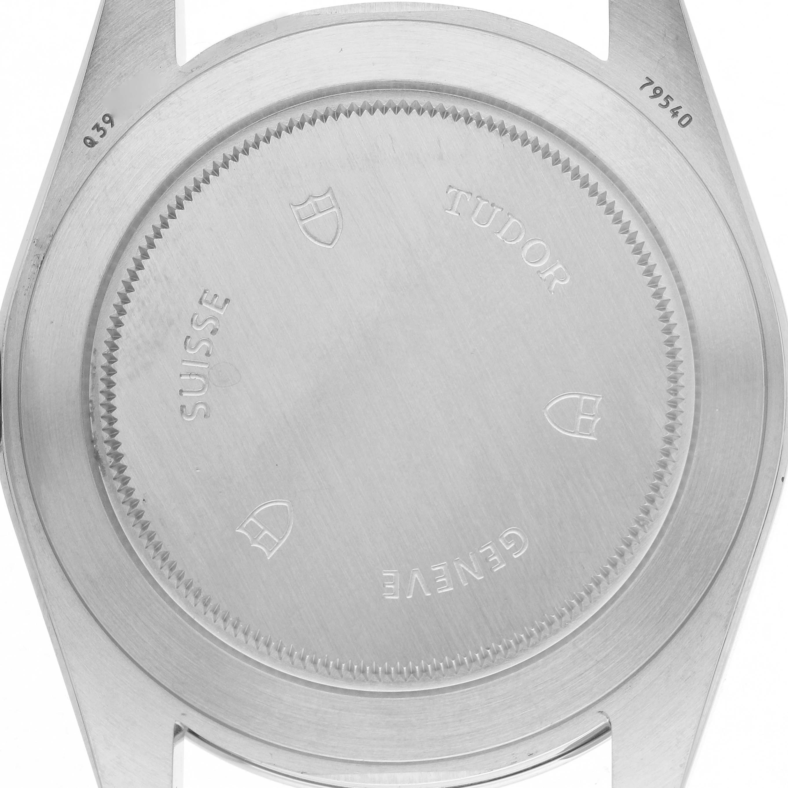The image shows the back casing of a Tudor Heritage Black Bay M79540 Men's Stainless Steel Silver Dial watch, featuring engravings and a stainless steel finish.