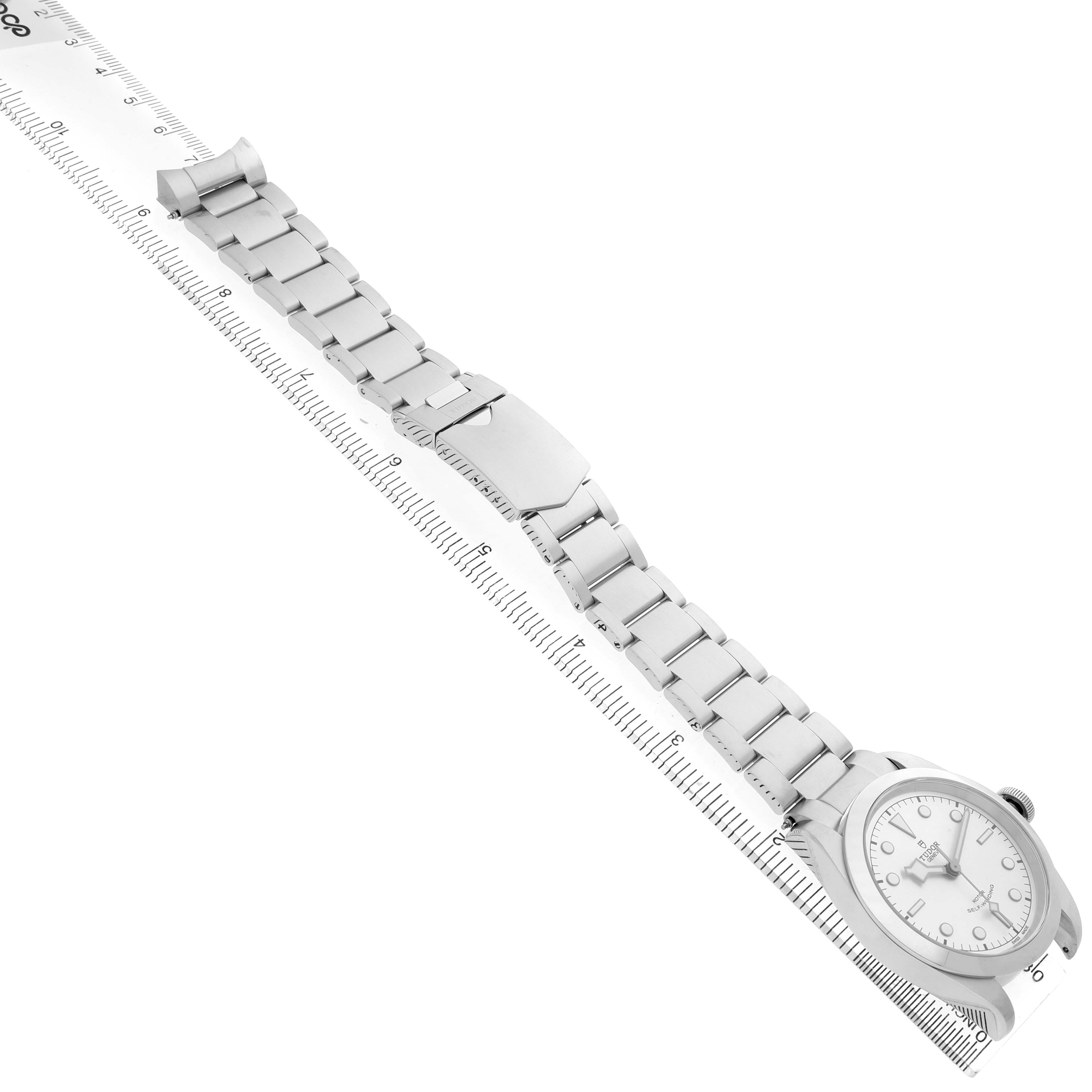 The Tudor Heritage Black Bay M79540 Men's Stainless Steel Silver Dial watch is shown from a top-down angle, highlighting the bracelet and clasp.