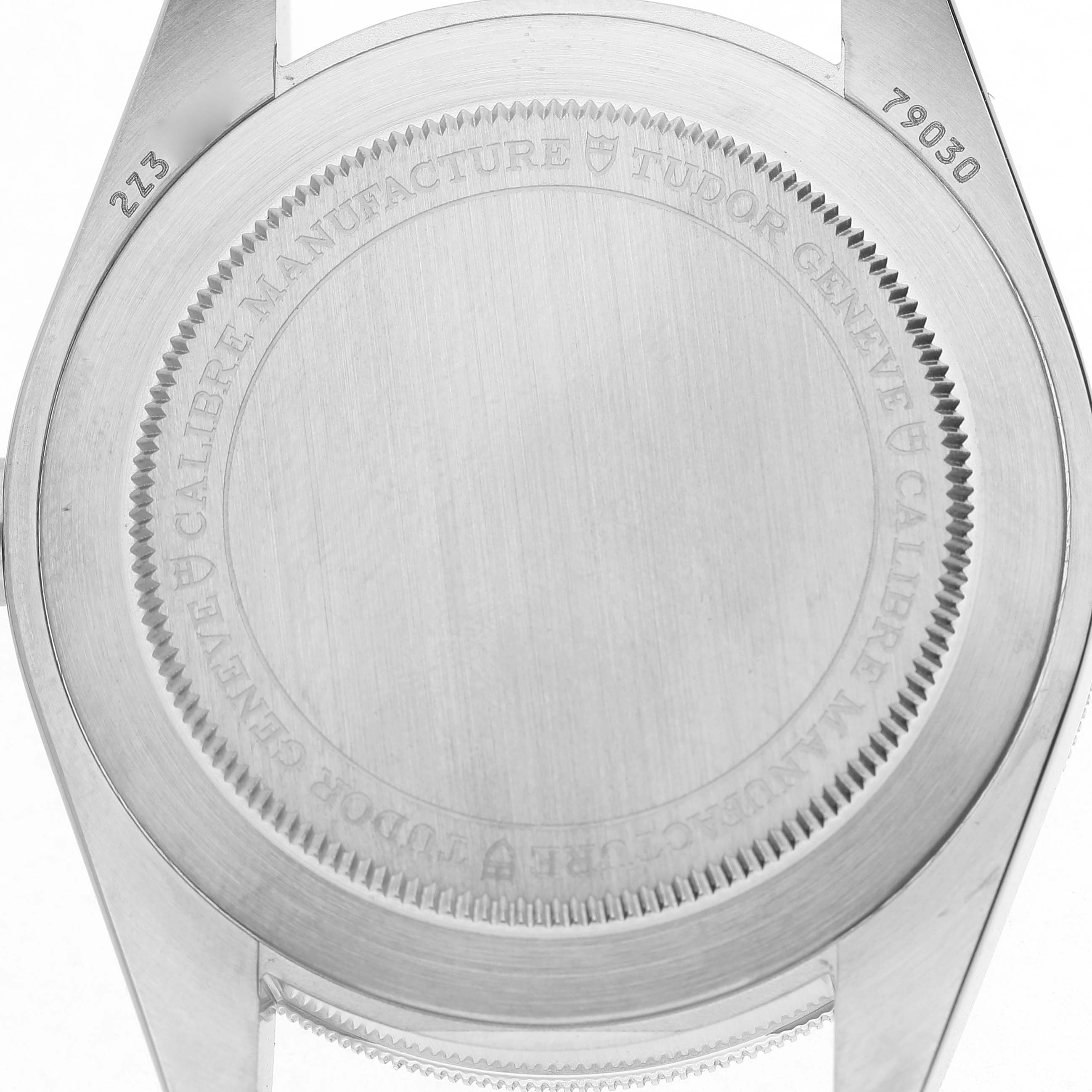 The image shows the back case of the Tudor Heritage Black Bay 79030 Men's Stainless Steel Black Dial watch, highlighting its engraving and serial numbers.
