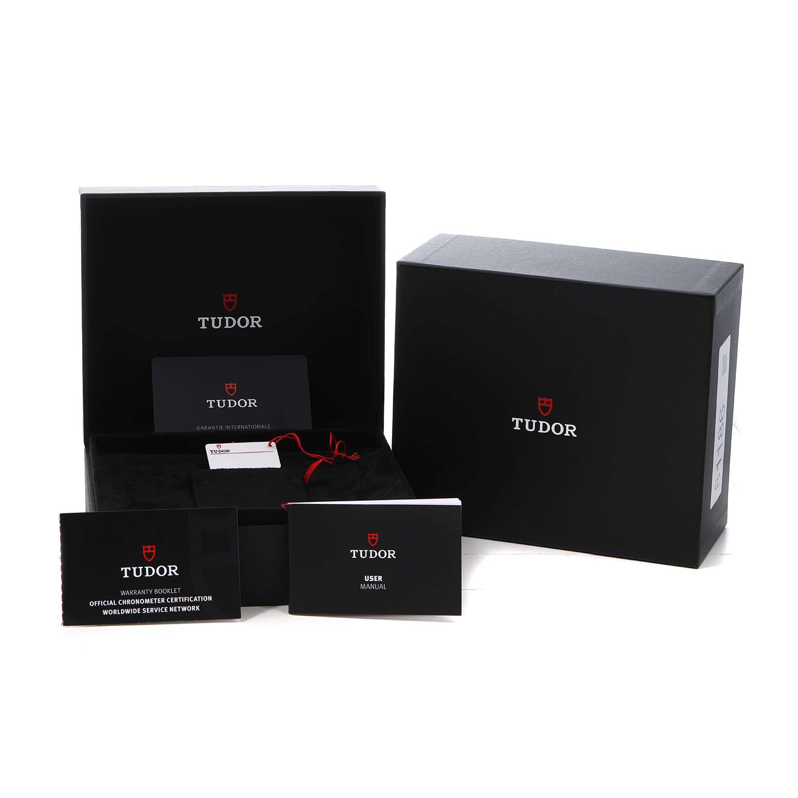 The Tudor Heritage Black Bay 79030 Men's Stainless Steel Black Dial watch accessories include its box, warranty booklet, and user manual, shown from a frontal angle.