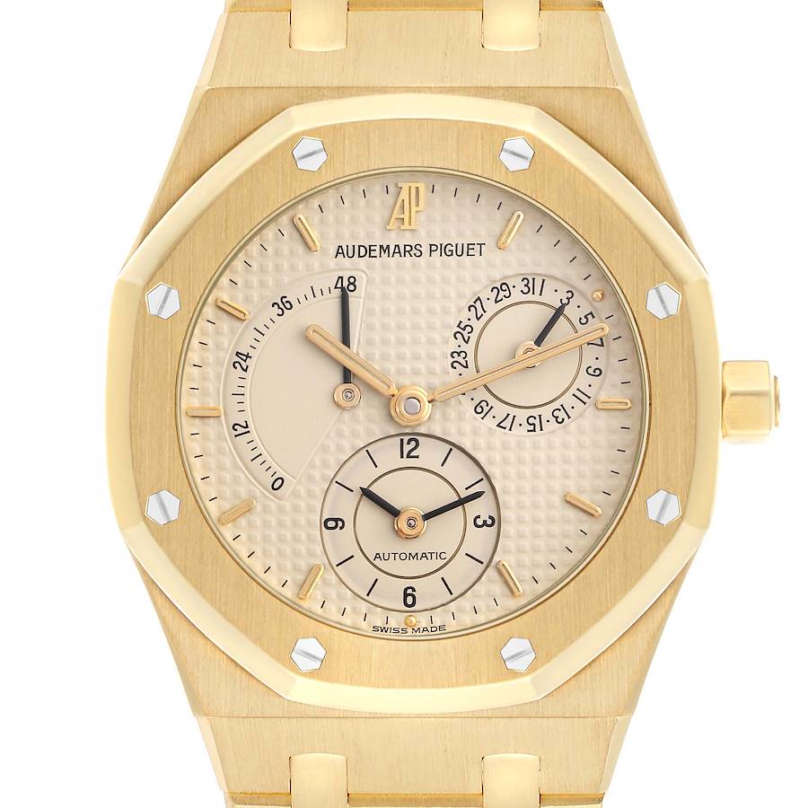 The image shows a front view of an Audemars Piguet Royal Oak watch, highlighting its gold case, dial, and subdials.