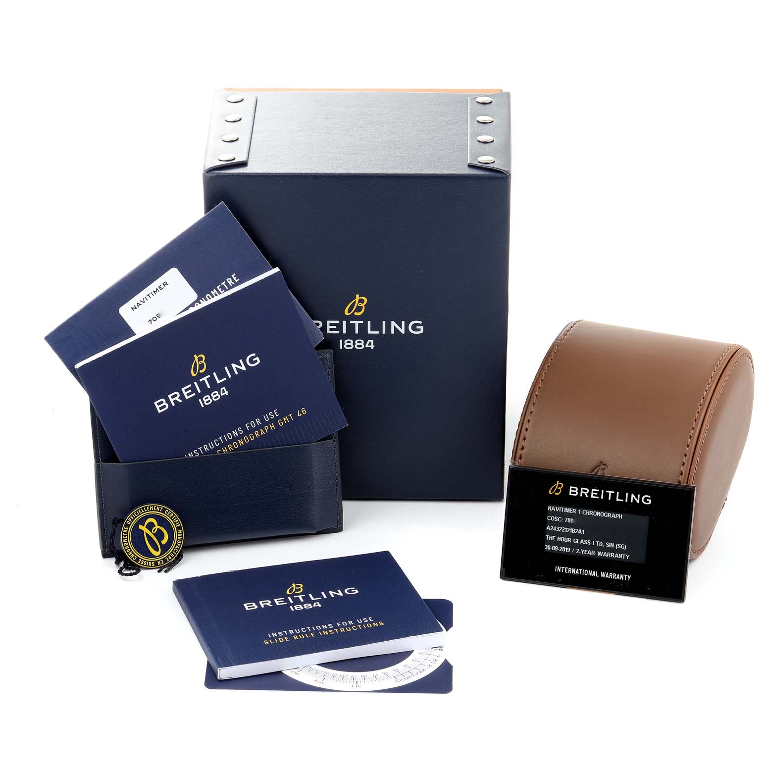 The image shows the Breitling Navitimer A24322 Men's Stainless Steel Black Dial A24322 Men's Stainless Steel Black Dial watch box, manuals, warranty card, and a brown leather travel case from a slightly angled top view.