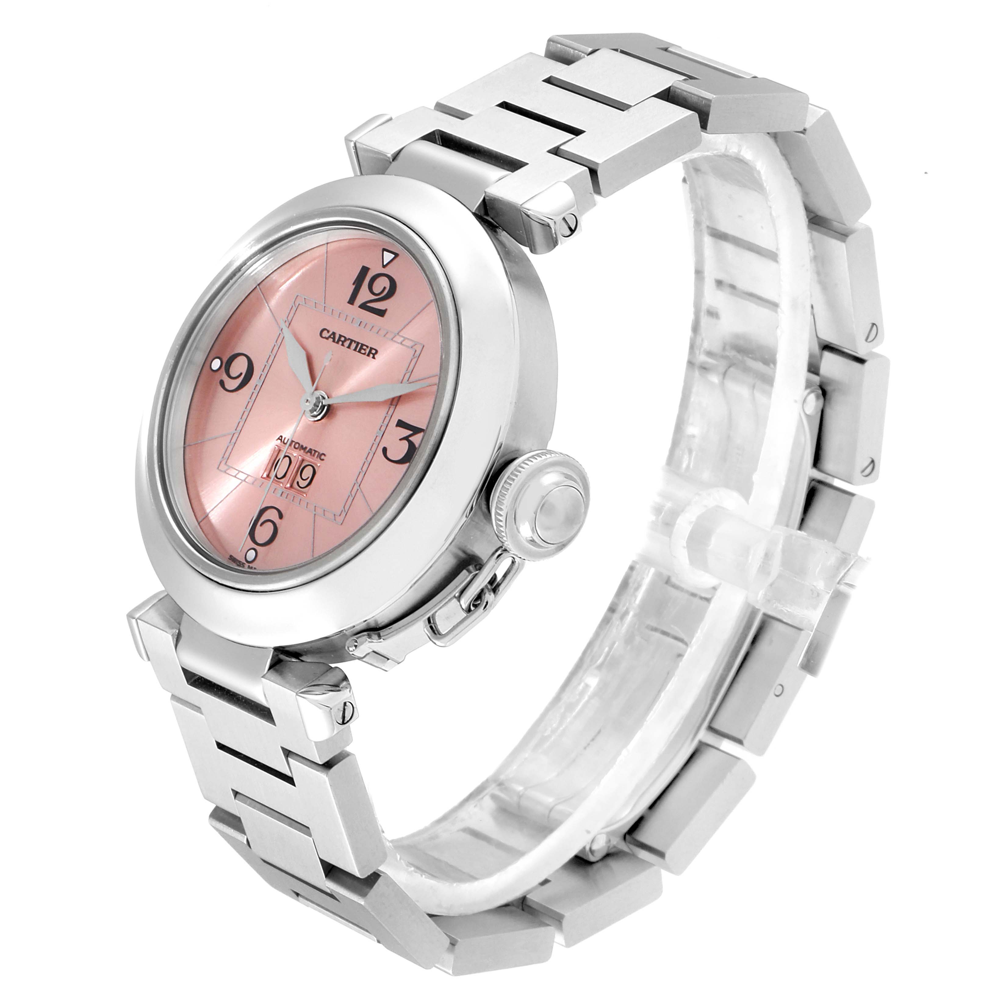 The image shows a Pasha model by Cartier at a diagonal angle, highlighting the pink dial, crown, and metallic bracelet.