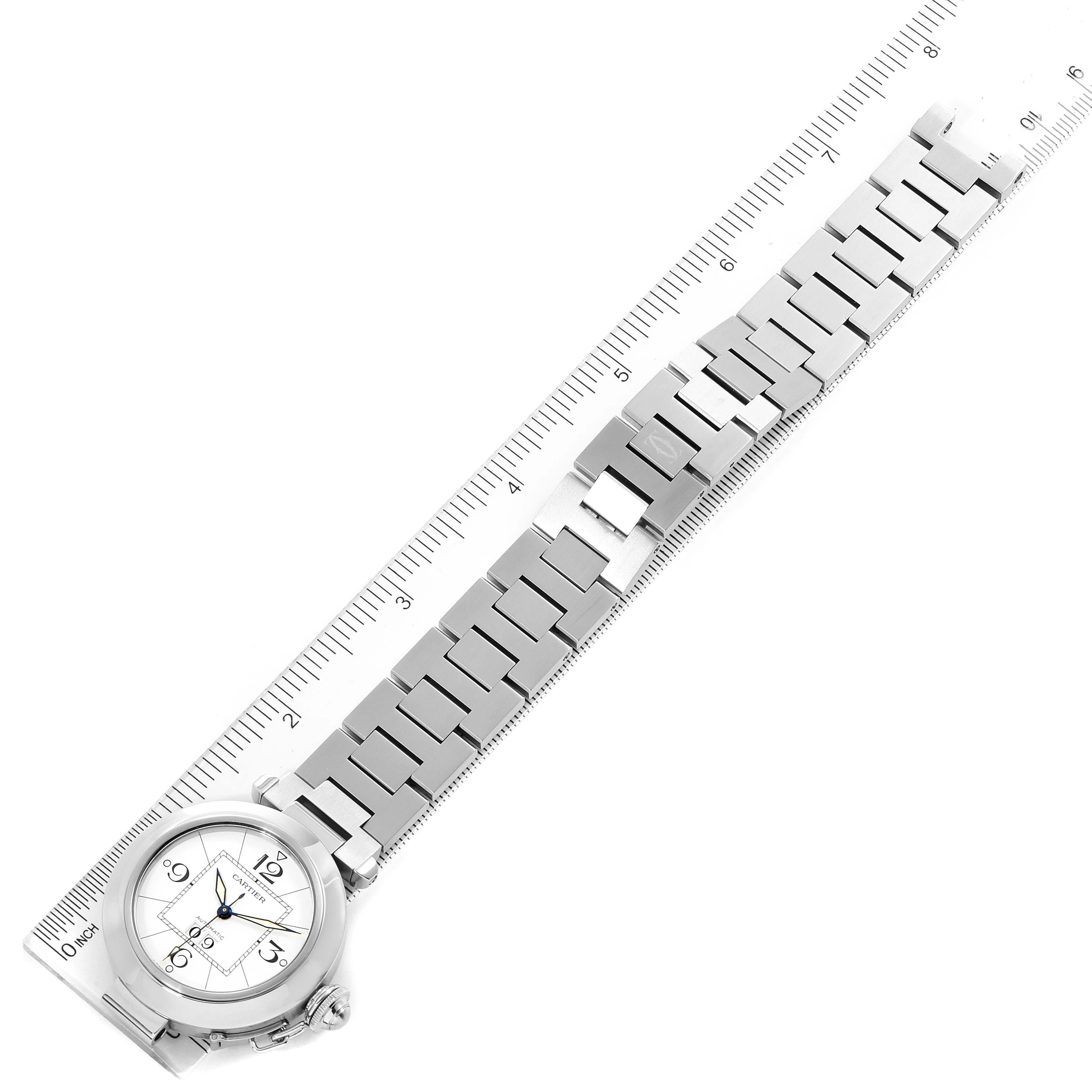 The Cartier Pasha W31055M7 Men's Stainless Steel White Dial W31055M7 Men's Stainless Steel White Dial watch is shown from a top-down angle, displaying the full bracelet and part of a ruler for scale.