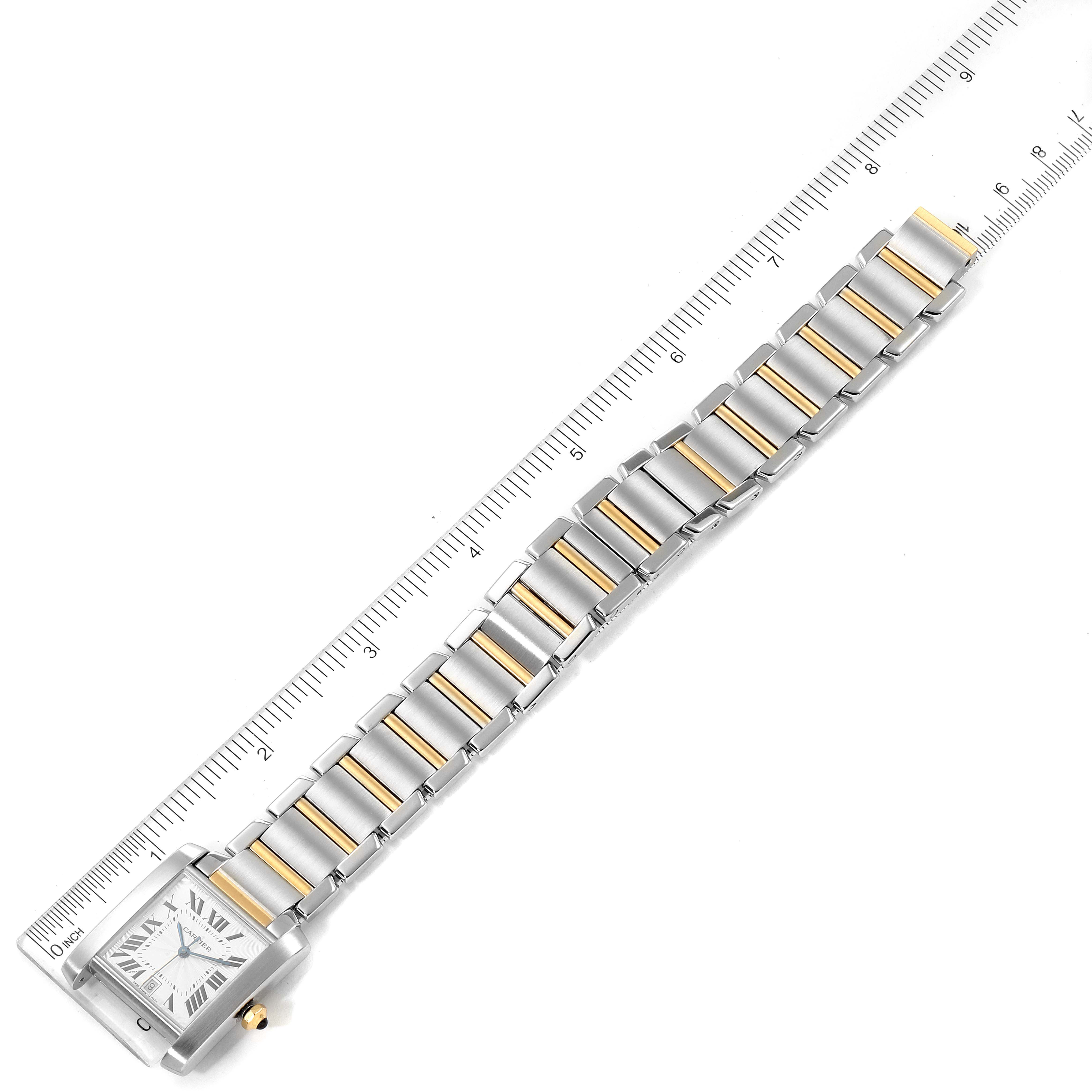 The image shows a Cartier Tank Française watch from an angled, top-down view, highlighting the face, bracelet, and clasp alongside a ruler for scale.