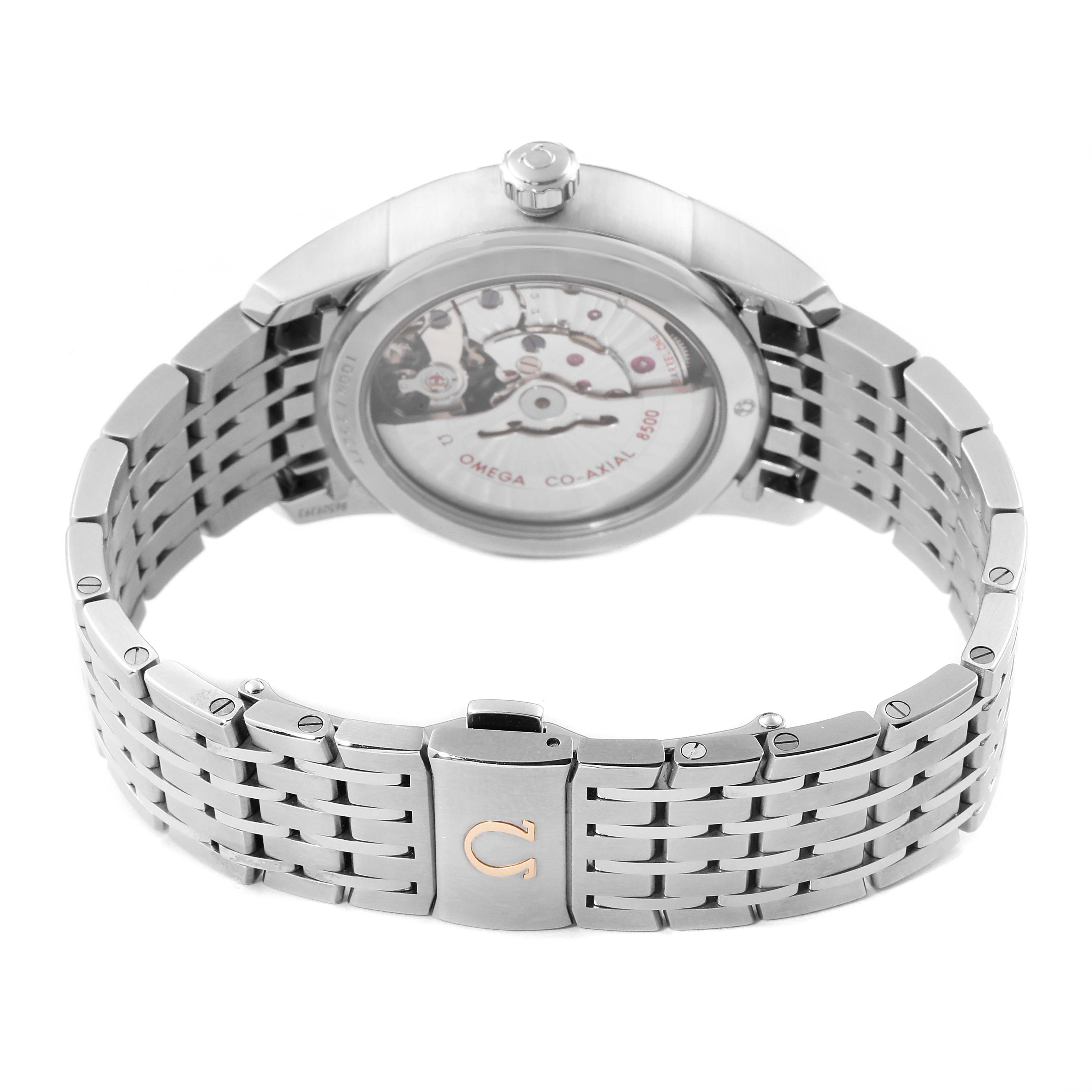 The image shows the back view of the De Ville model by Omega, highlighting the open case back and the metal bracelet.