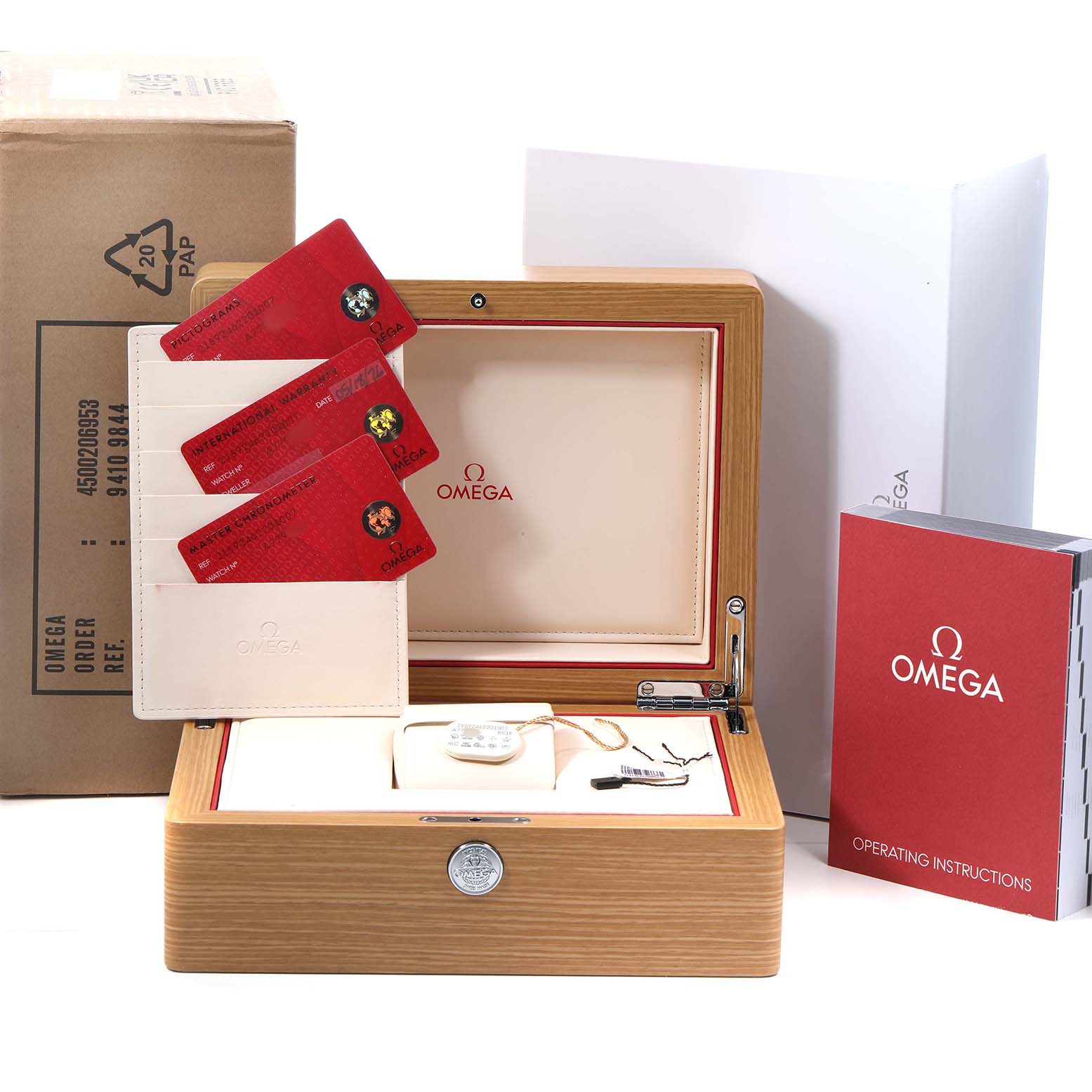 The image shows an Omega Planet Ocean 215.92.46.22.01.007 Men's Ceramic Black Dial watch presentation box with cards, a manual, and packaging components.