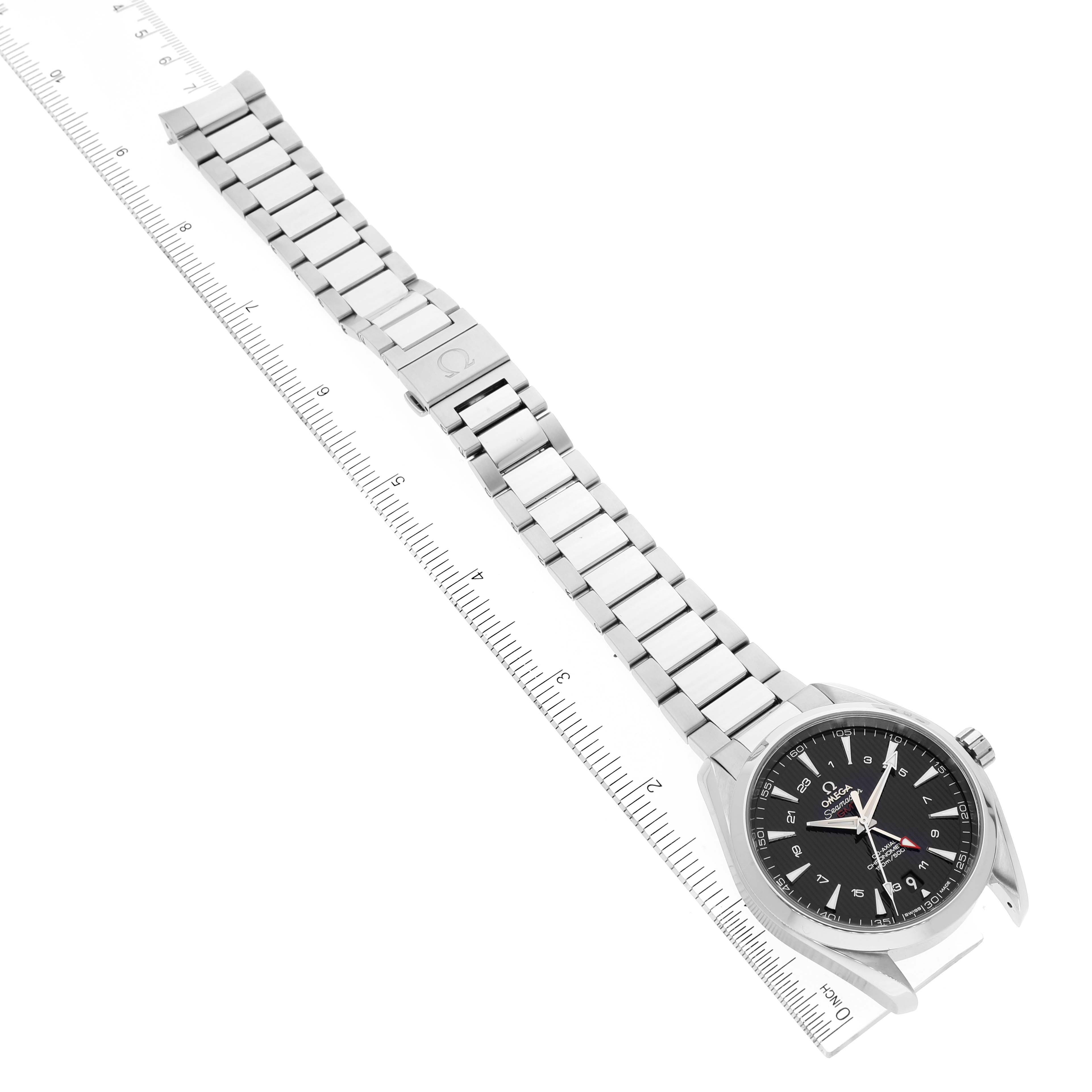 The image shows an aerial view of the Omega Aqua Terra 231.10.43.22.01.001 Men's Stainless Steel Black Dial 231.10.43.22.01.001 Men's Stainless Steel Black Dial watch, highlighting its face, metal bracelet, and a ruler for scale.