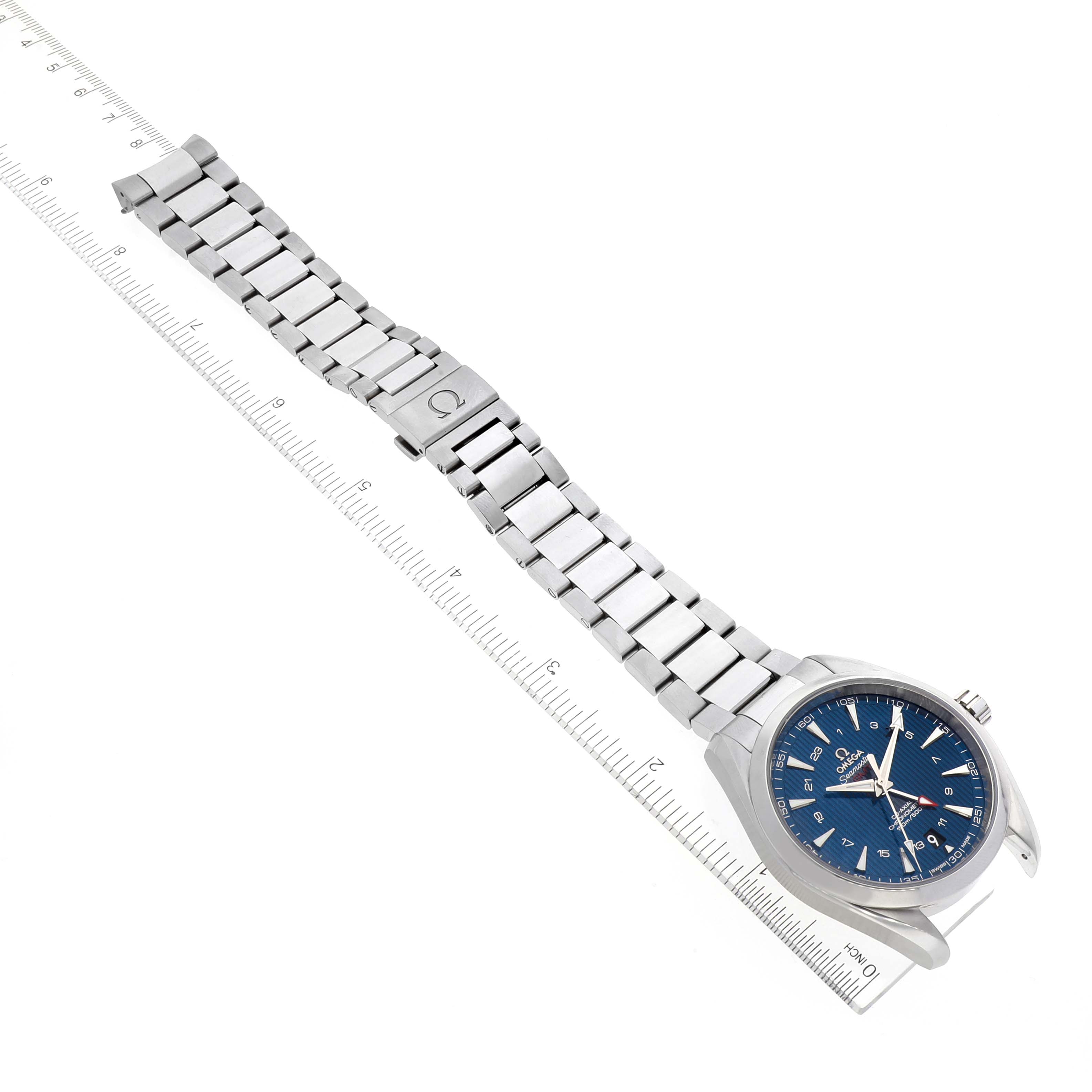 This image shows the Omega Aqua Terra 231.10.43.22.03.001 Men
s Stainless Steel Blue Dial 231.10.43.22.03.001 Men
s Stainless Steel Blue Dial watch from a top-down angle, focusing on its face, bracelet, and clasp, alongside a ruler.