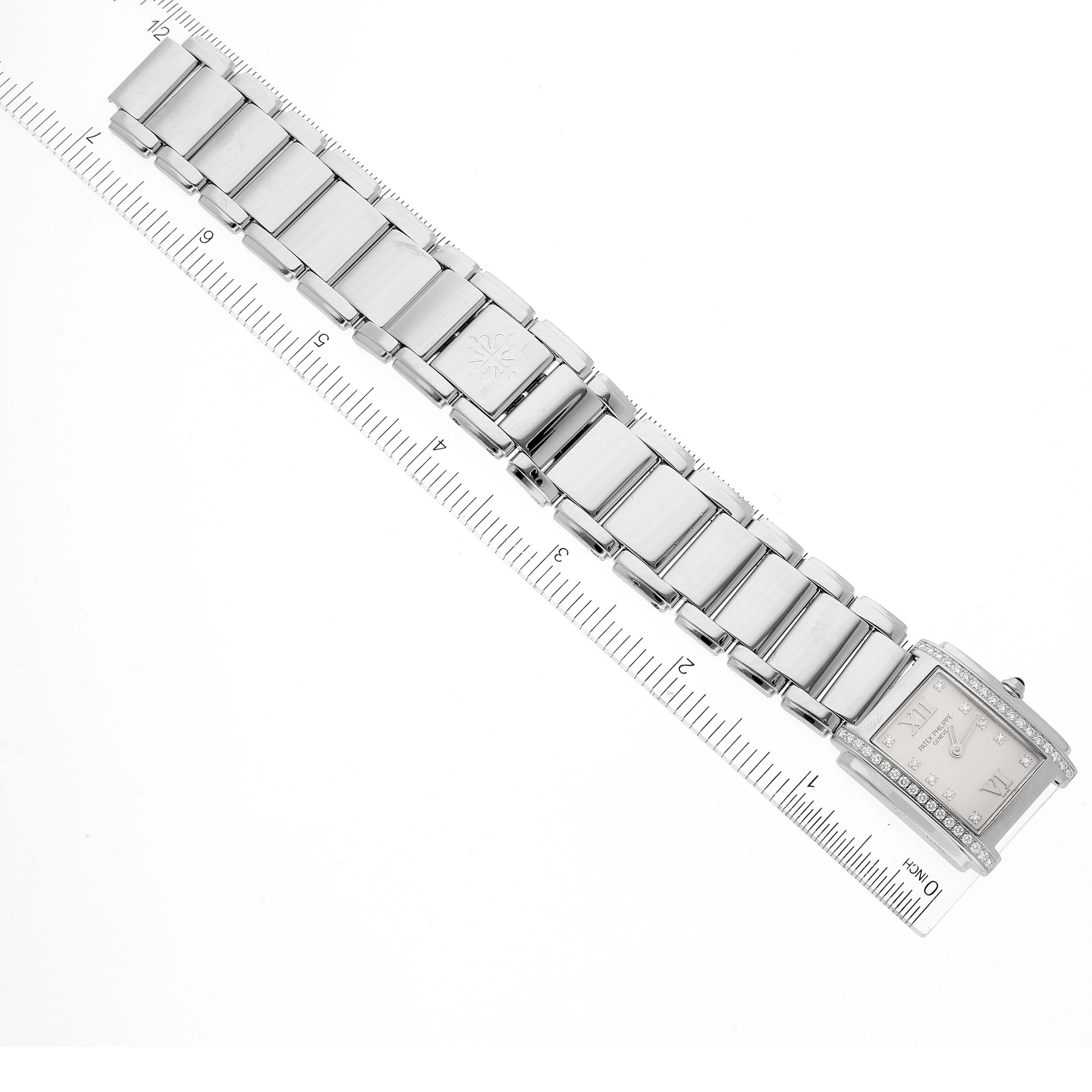 The Patek Philippe Twenty-4 4910/10A-010 Women's Stainless Steel Silver Dial 4910/10A-010 Women's Stainless Steel Silver Dial watch is shown at a diagonal angle, highlighting its face and bracelet with a ruler for scale.