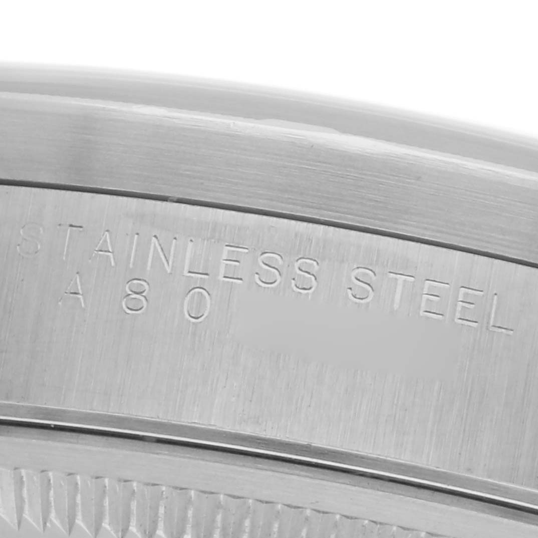 The image shows the side engraving on the bezel of a Rolex Date 15210 Men
s Stainless Steel Blue Dial 15210 Men
s Stainless Steel Blue Dial model, focusing on the stainless steel text.