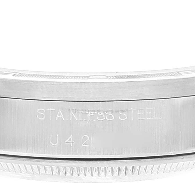 The image shows a close-up of the side casing of a Rolex Date 15210 Men's Stainless Steel Blue Dial 15210 Men's Stainless Steel Blue Dial model watch, highlighting the "STAINLESS STEEL" engraving.