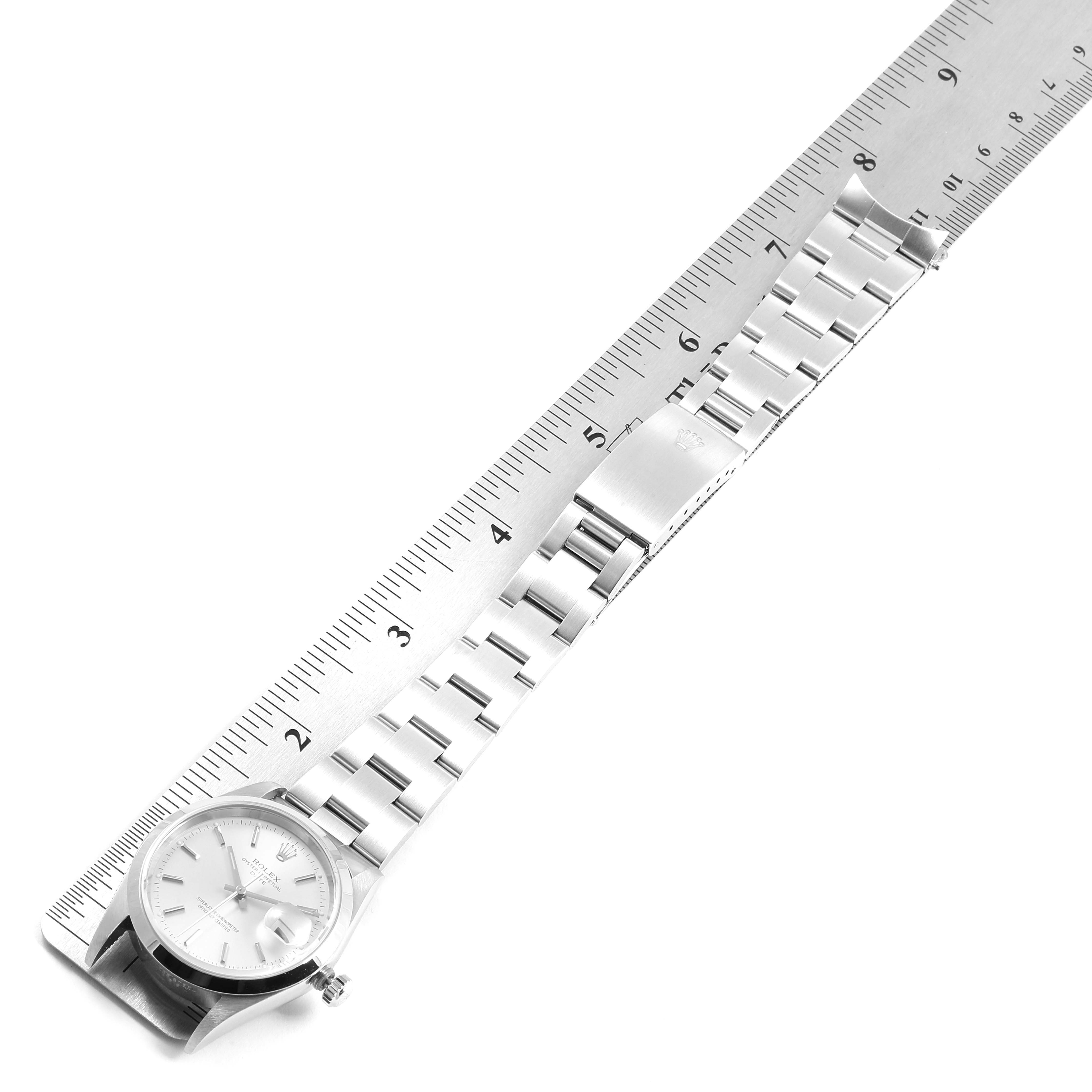The image shows a top-down view of a Rolex Date 15200 Men's Stainless Steel Silver Dial 15200 Men's Stainless Steel Silver Dial model watch with its stainless steel bracelet laid out beside a ruler.